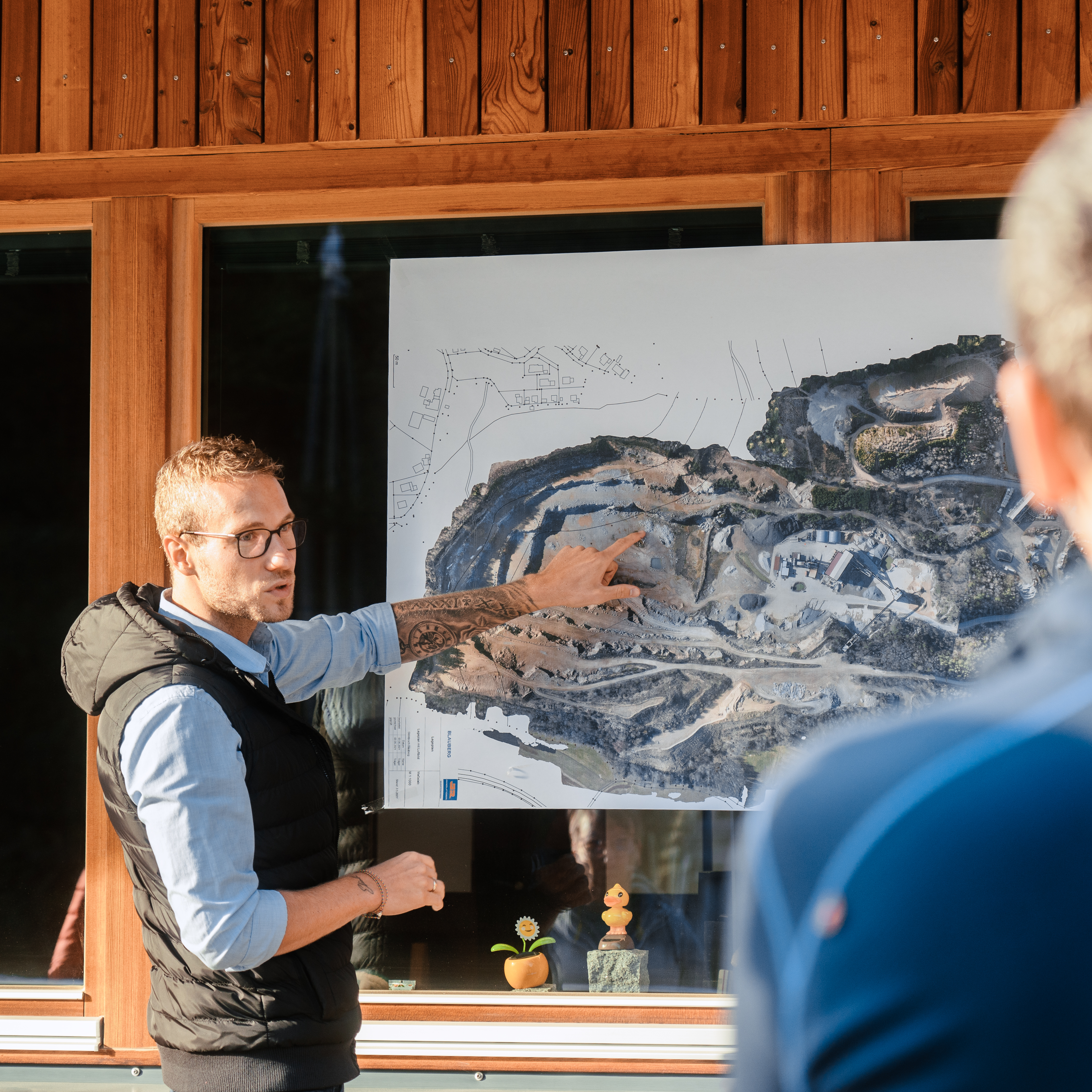 Betriebsleiter Jeremias Geißler erklärt dem Gemeinderat Runding den Grundriss des Steinbruchs Blauberg