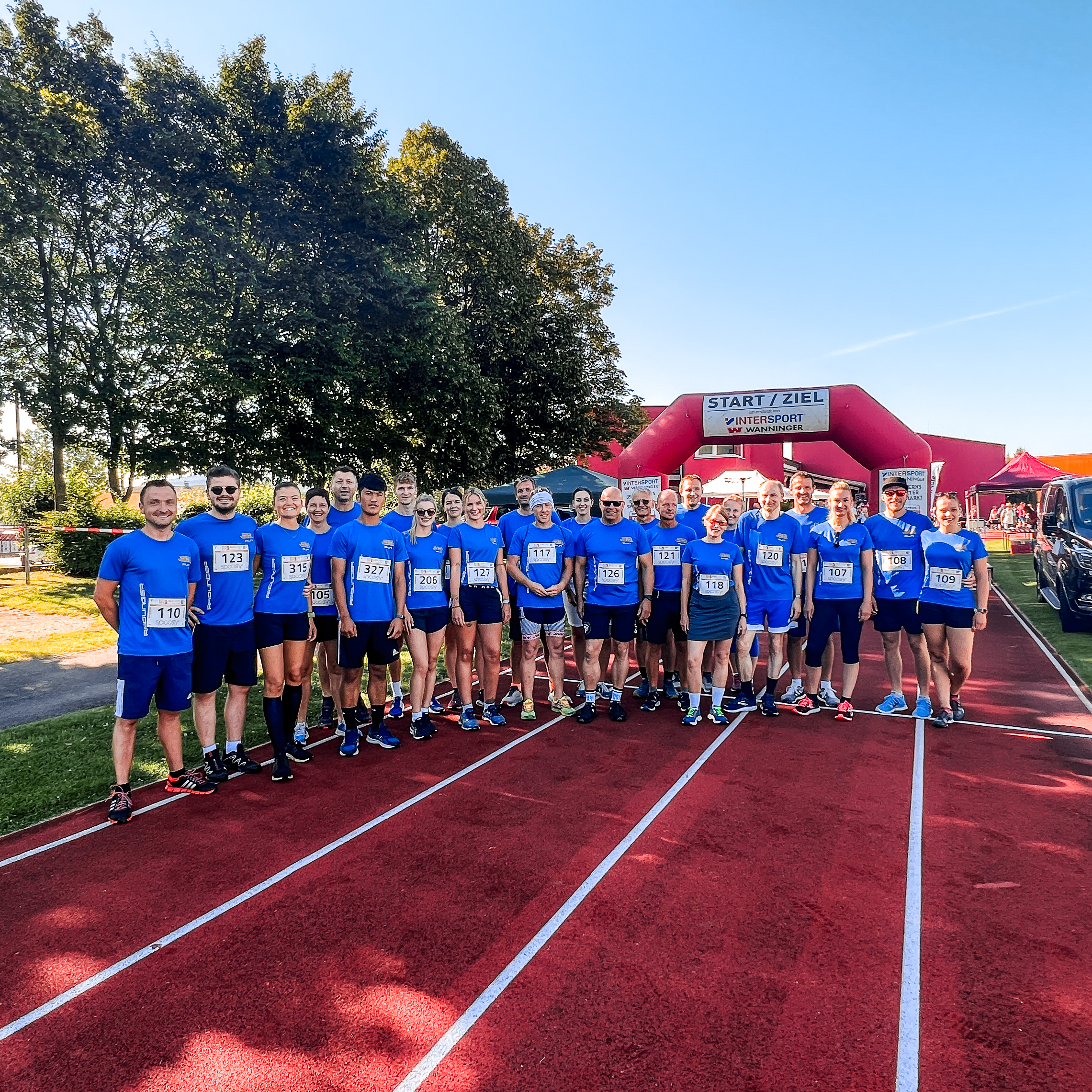 Gruppenfoto von allen Rädlinger Teilnehmern in gleichen blauen Shirts vor dem Ziel