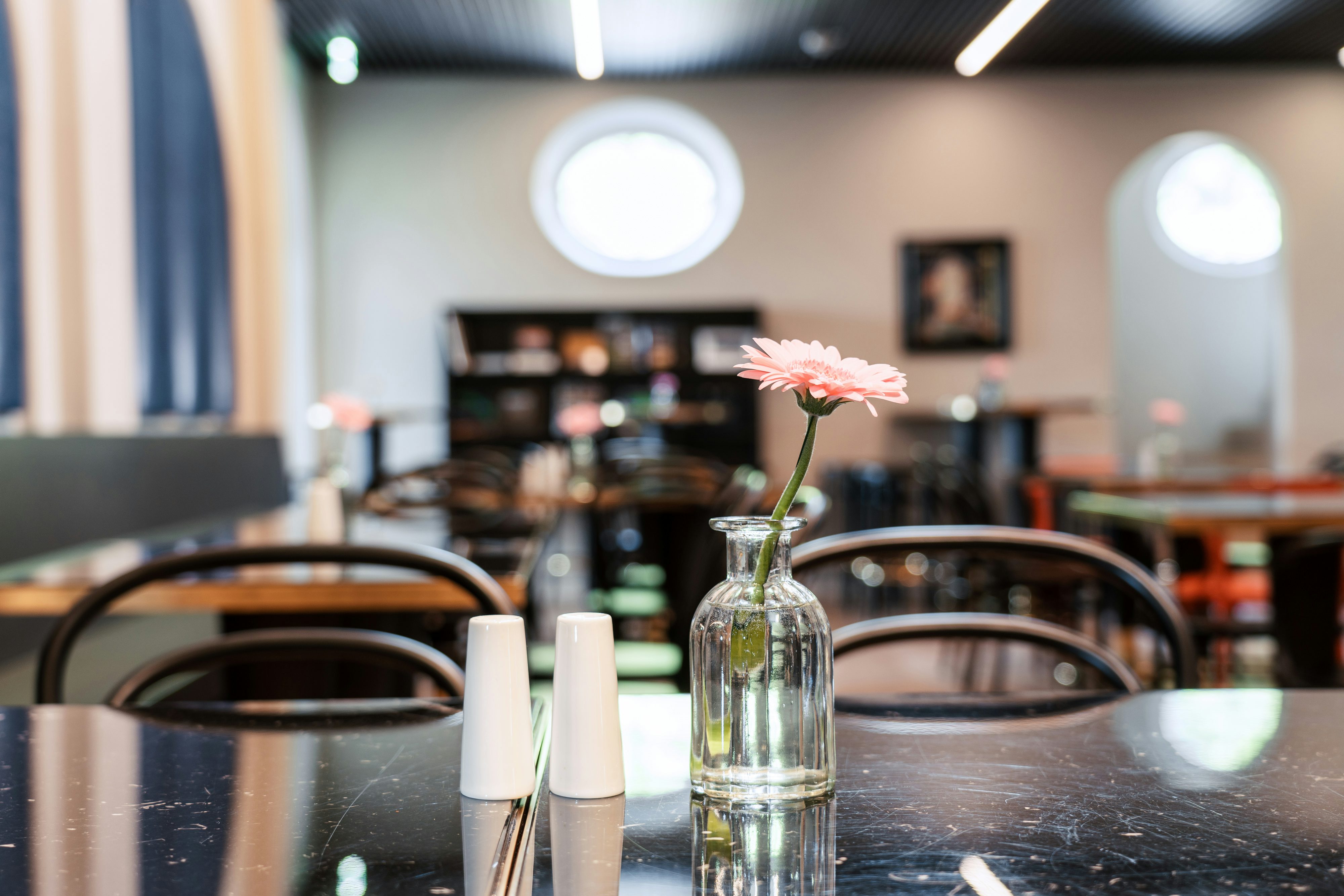 Speisesaal im Mitarbeiterrestaurant der Josef Rädlinger Unternehmensgruppe: Detailaufnahme einer Blume in einer Vase auf einem Tisch