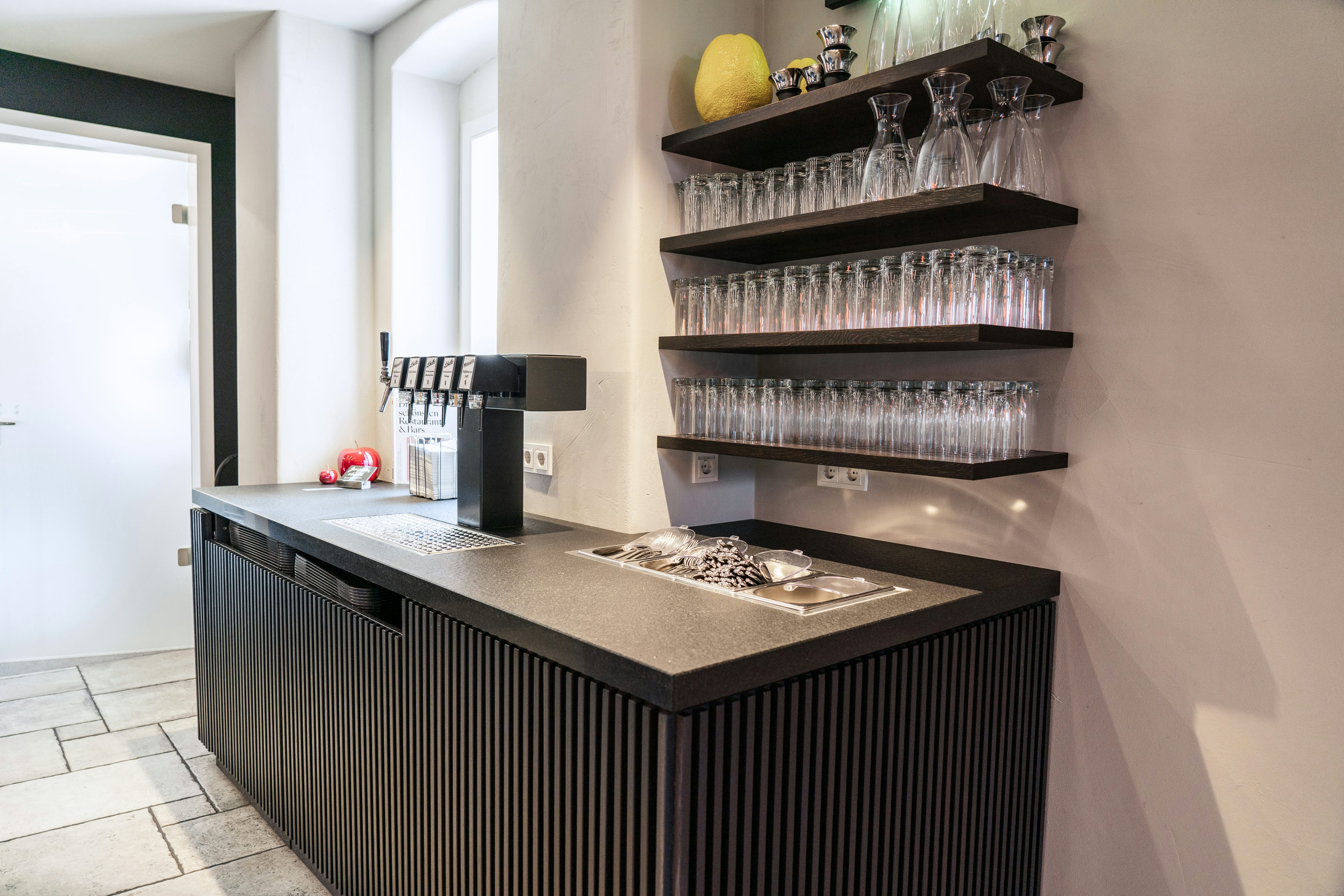 's Kloster von innen: Getränkestation mit Zapfhähnen und Gläsern