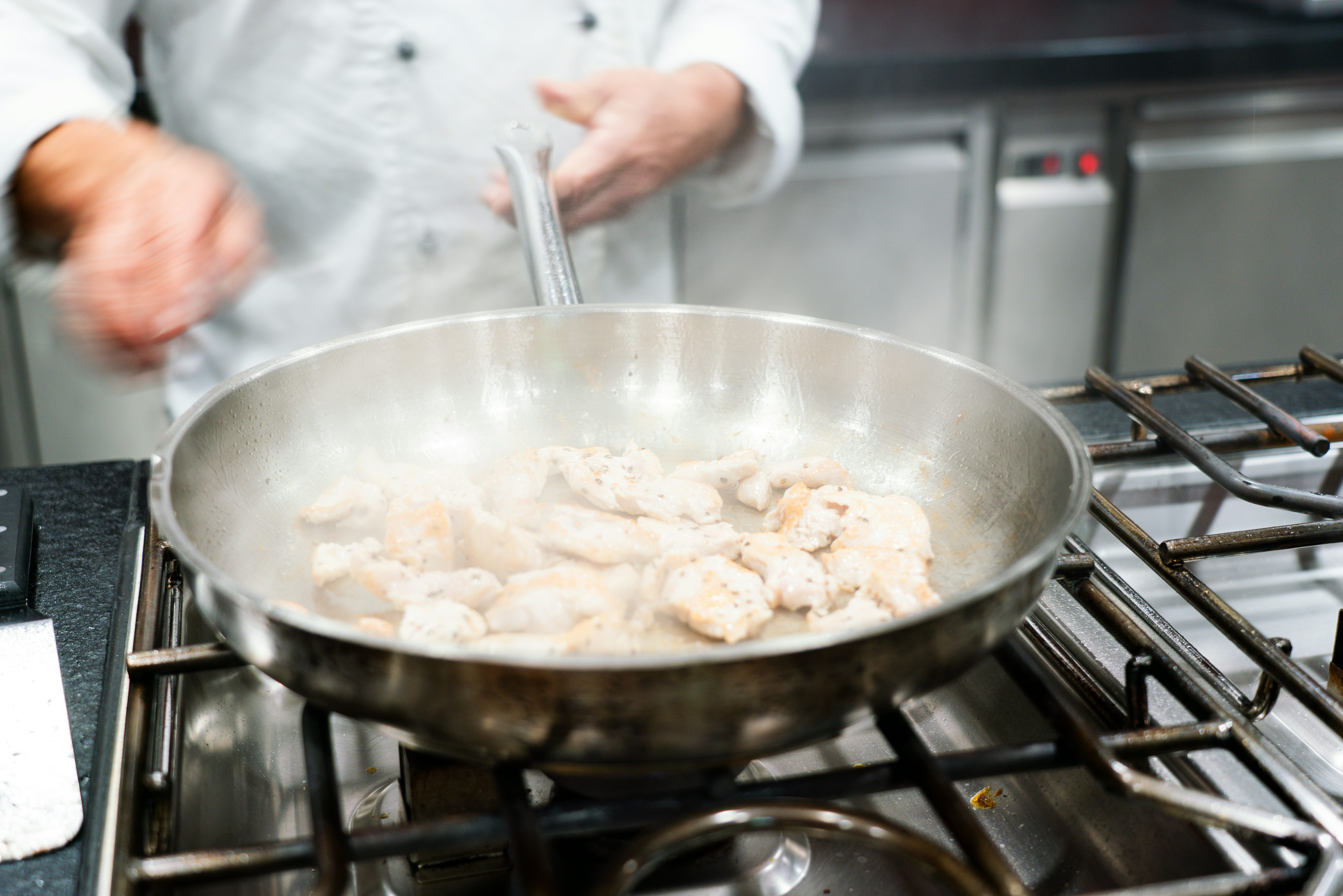 Kochen im 's Kloster: Koch brät Fleisch in einer Pfanne an