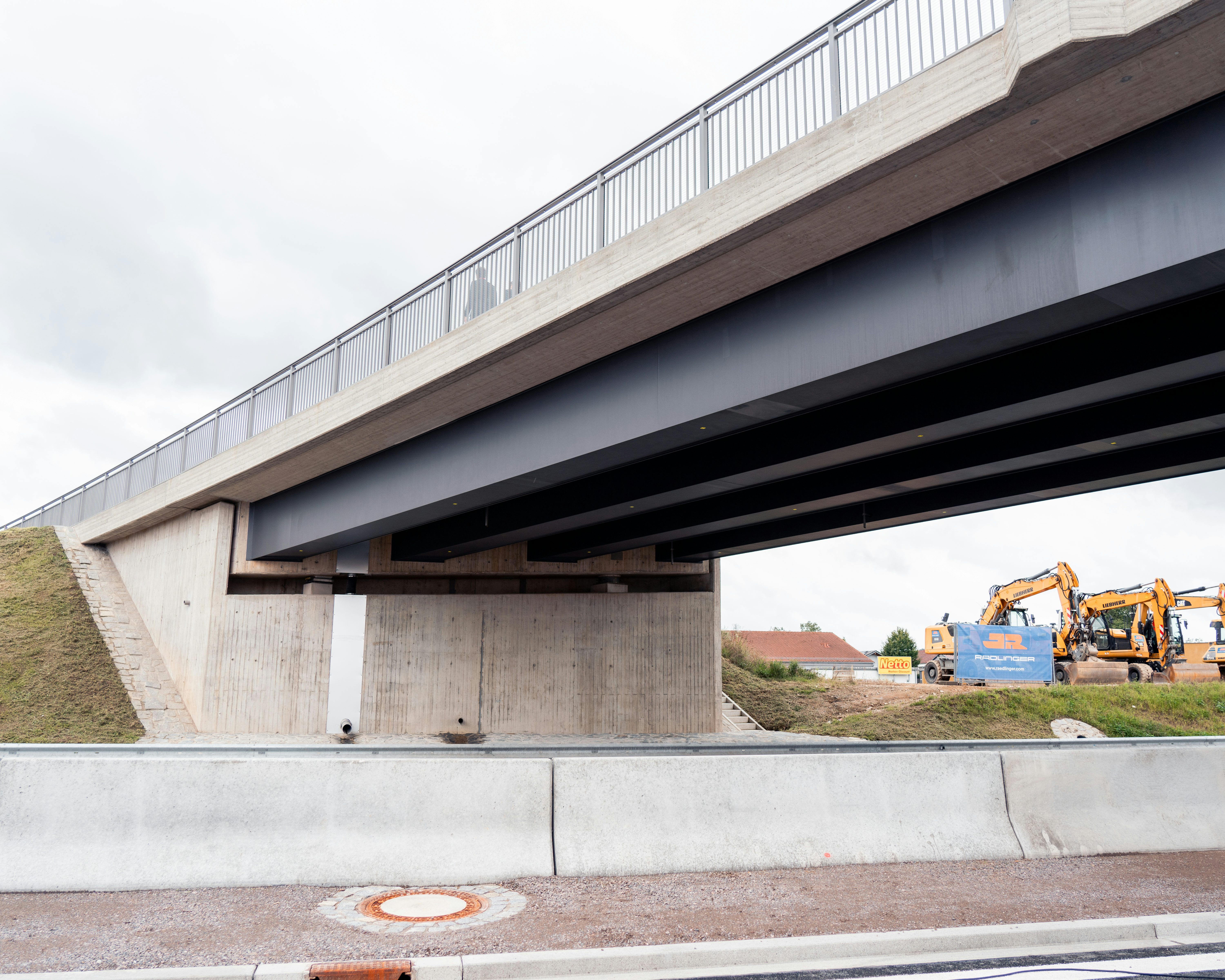 Freigabe B85 - Die neue Brücke mit Baustellenfahrzeugen im Hintergrund