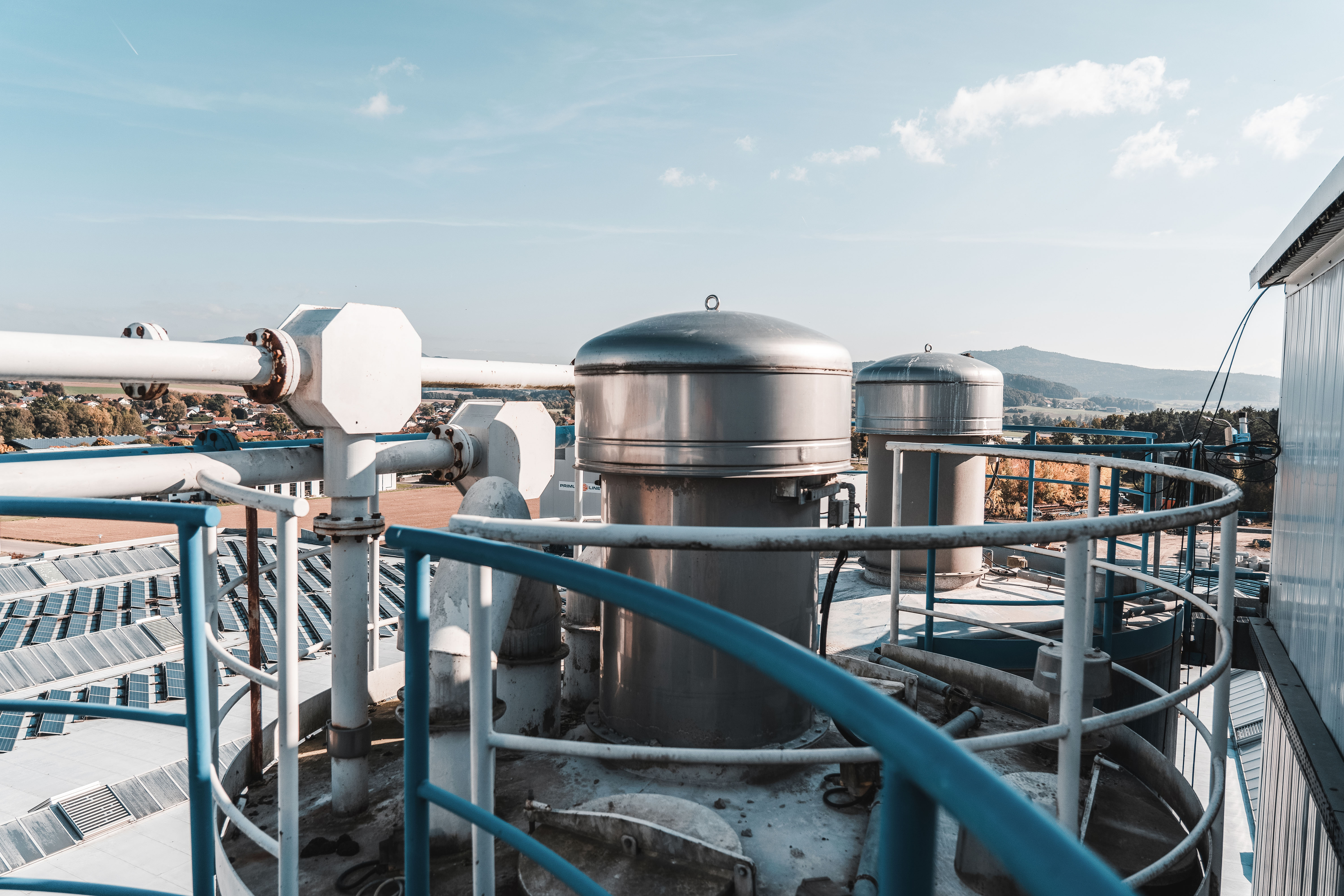 Über den Dächern des Betonwerks mit zwei der Silos im Vordergrund
