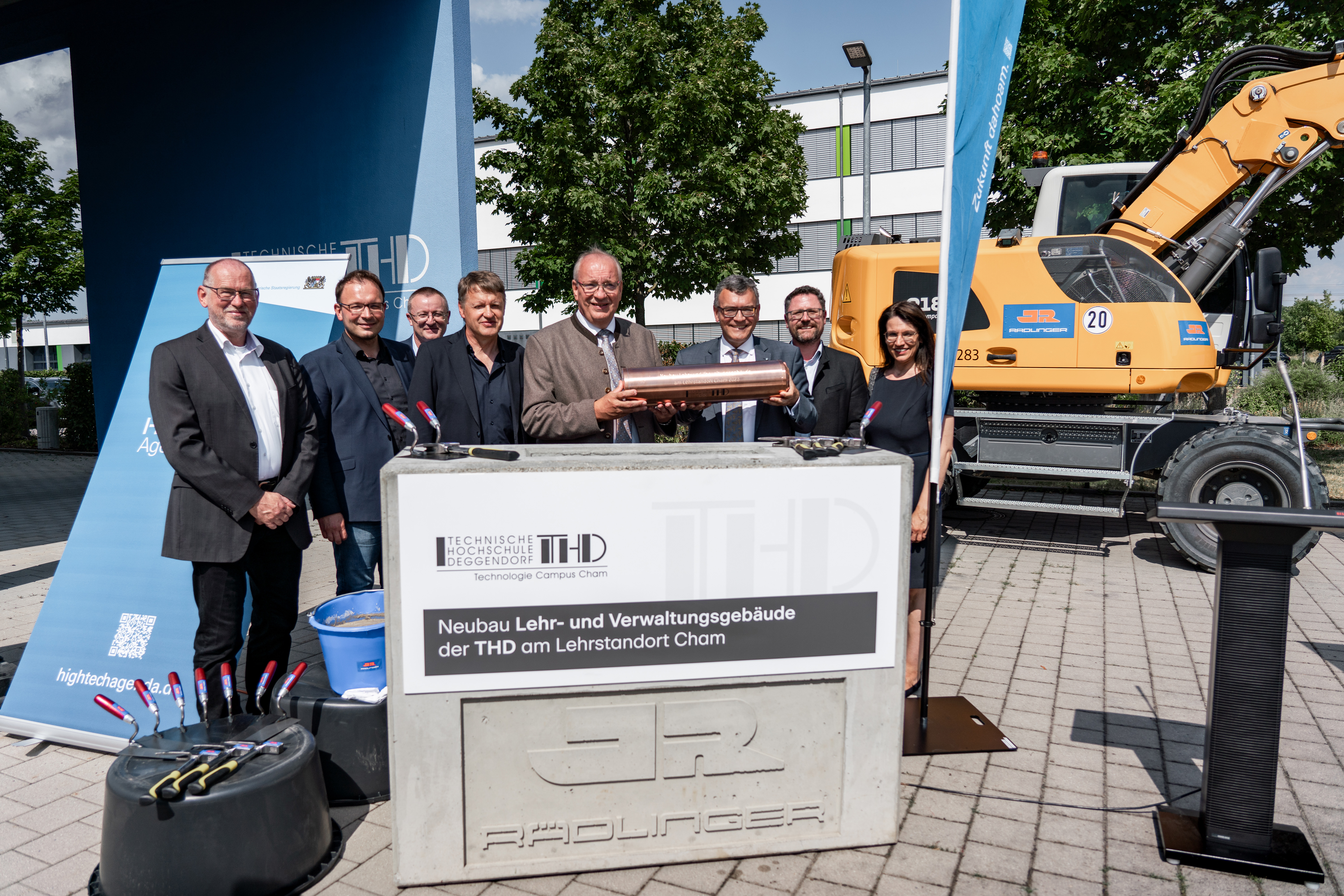 Die Ehrengäste versammeln sich um den Grundstein und lassen eine Zeitkapsel ein