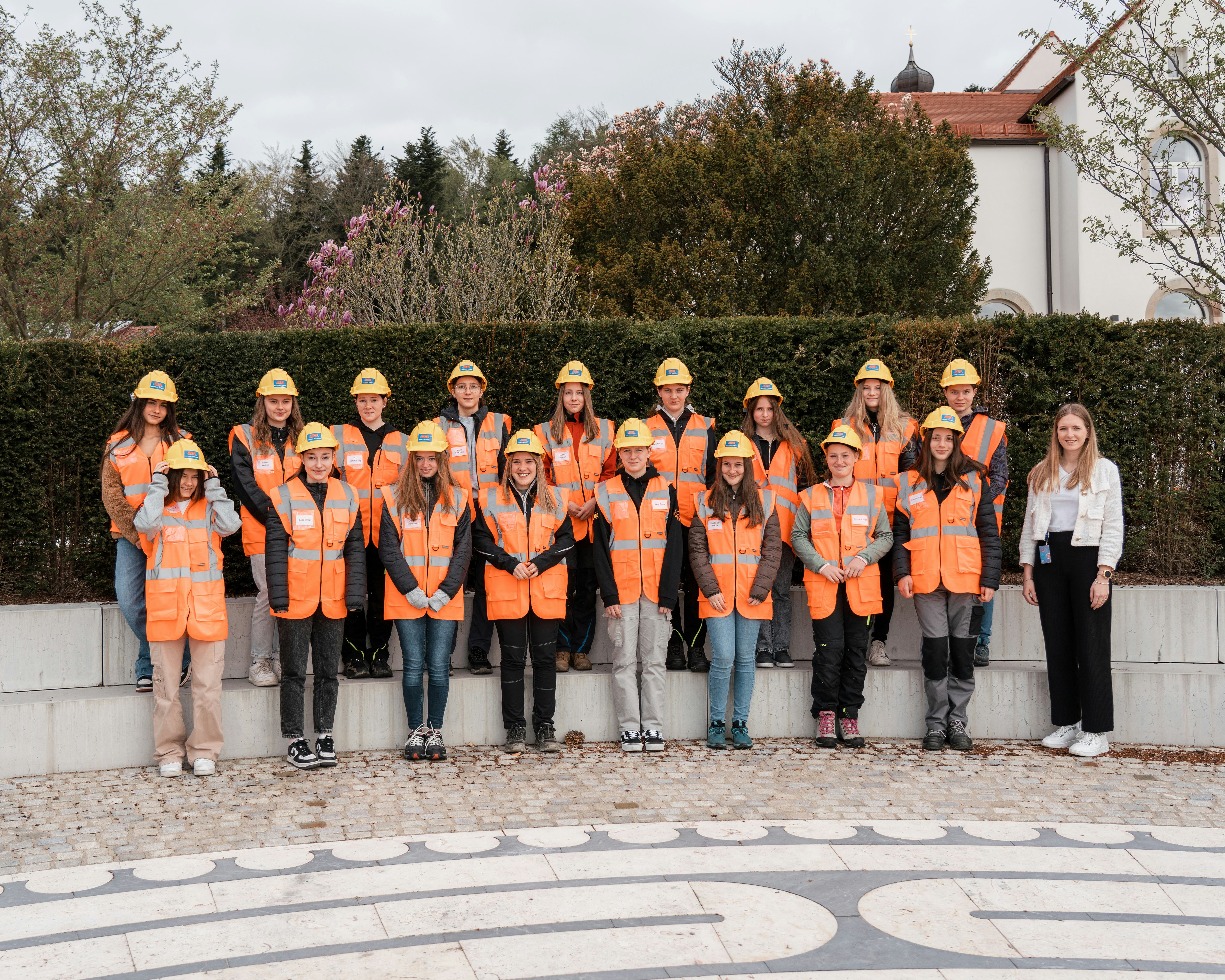 Girlsday 2023 bei Rädlinger: Gruppenfoto der Teilnehmerinnen mit Warnweste und Bauhelm im Firmengarten der Hauptverwaltung in Cham