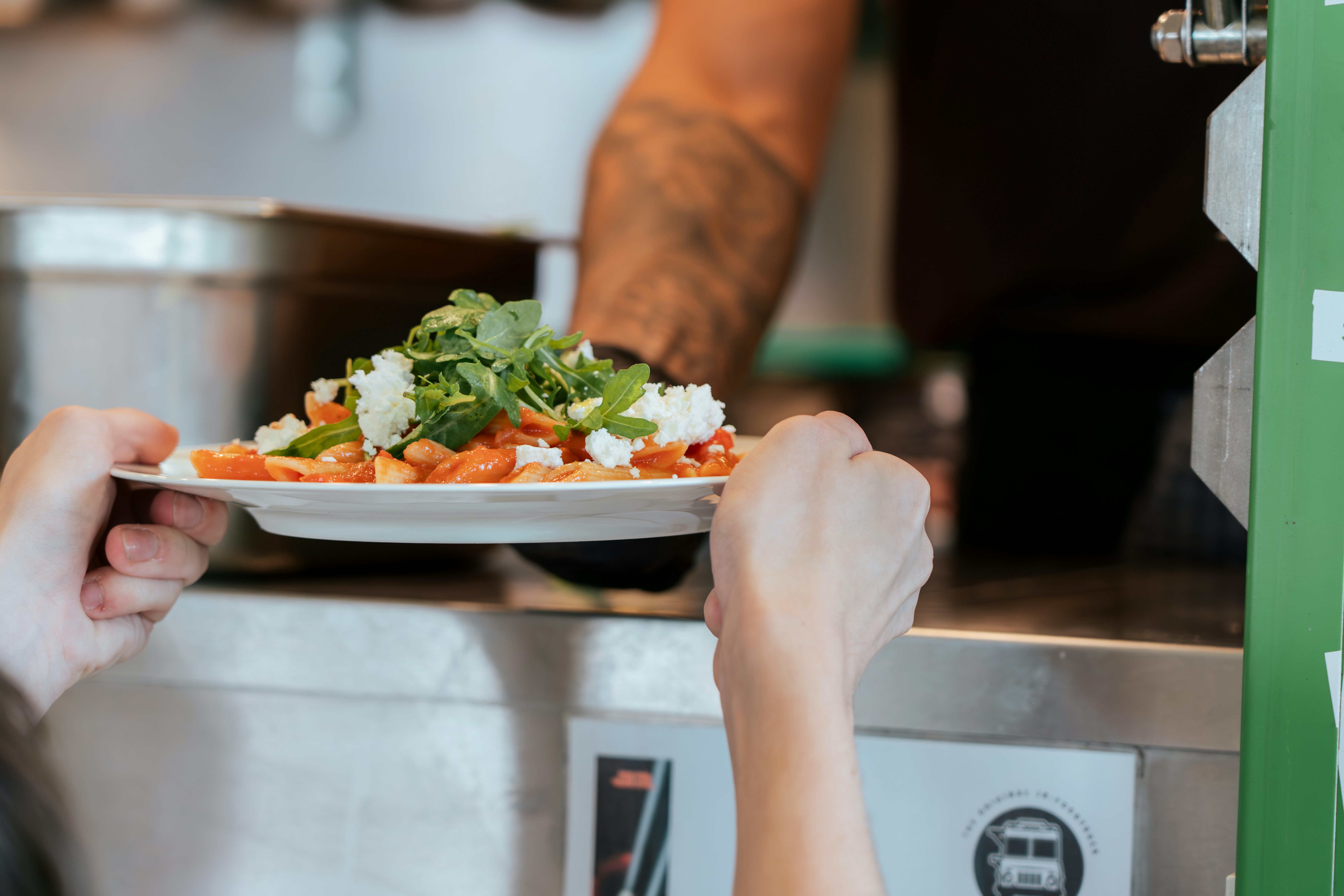 JR Foodtruck: Pasta mit Tomatensauce, Ziegenkäse und Rucola auf einem Teller