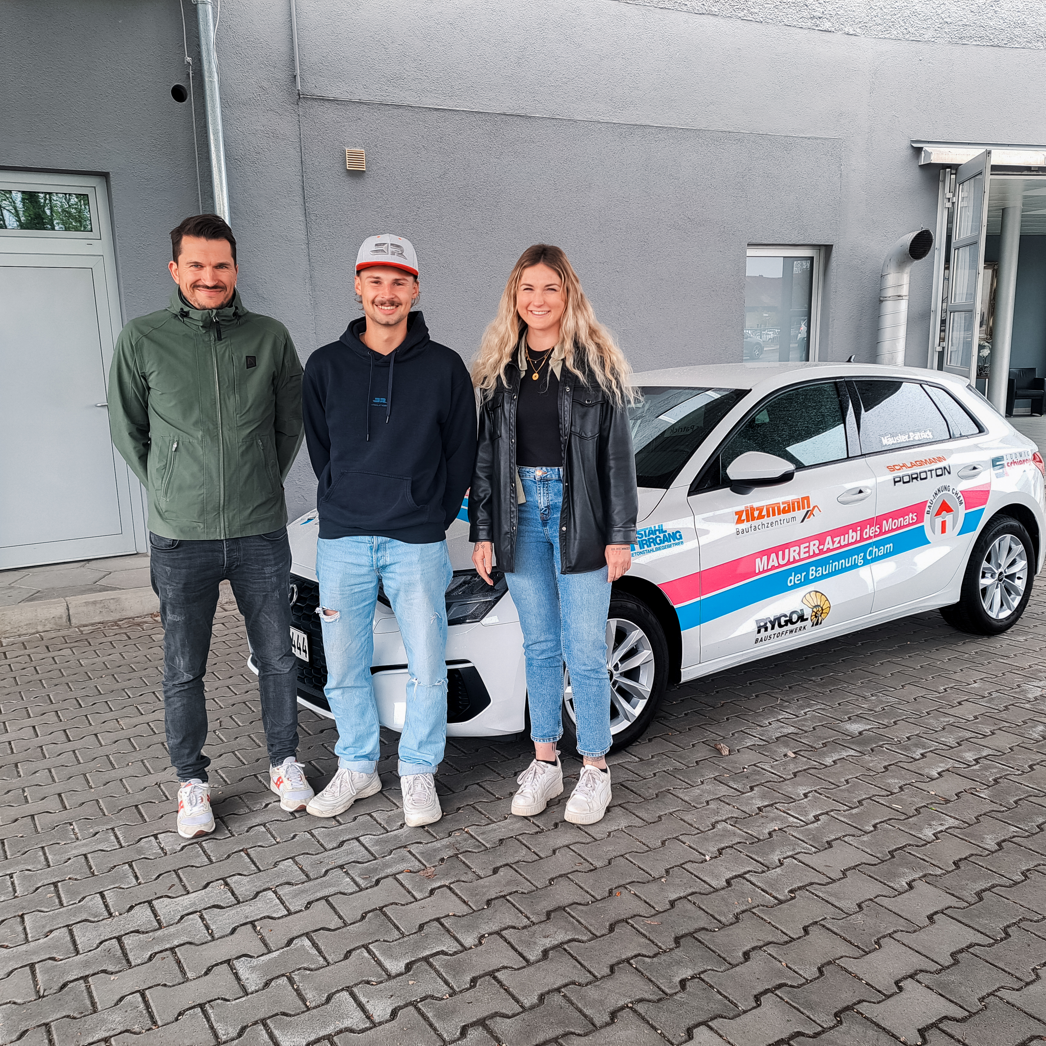 Maurer Azubi Patrick Häusler zusammen mit den beiden Ausbildungsbetreuern Nathalie Hirmer und Dominik Fischer bei der offiziellen Übergabe des Innungsautos.