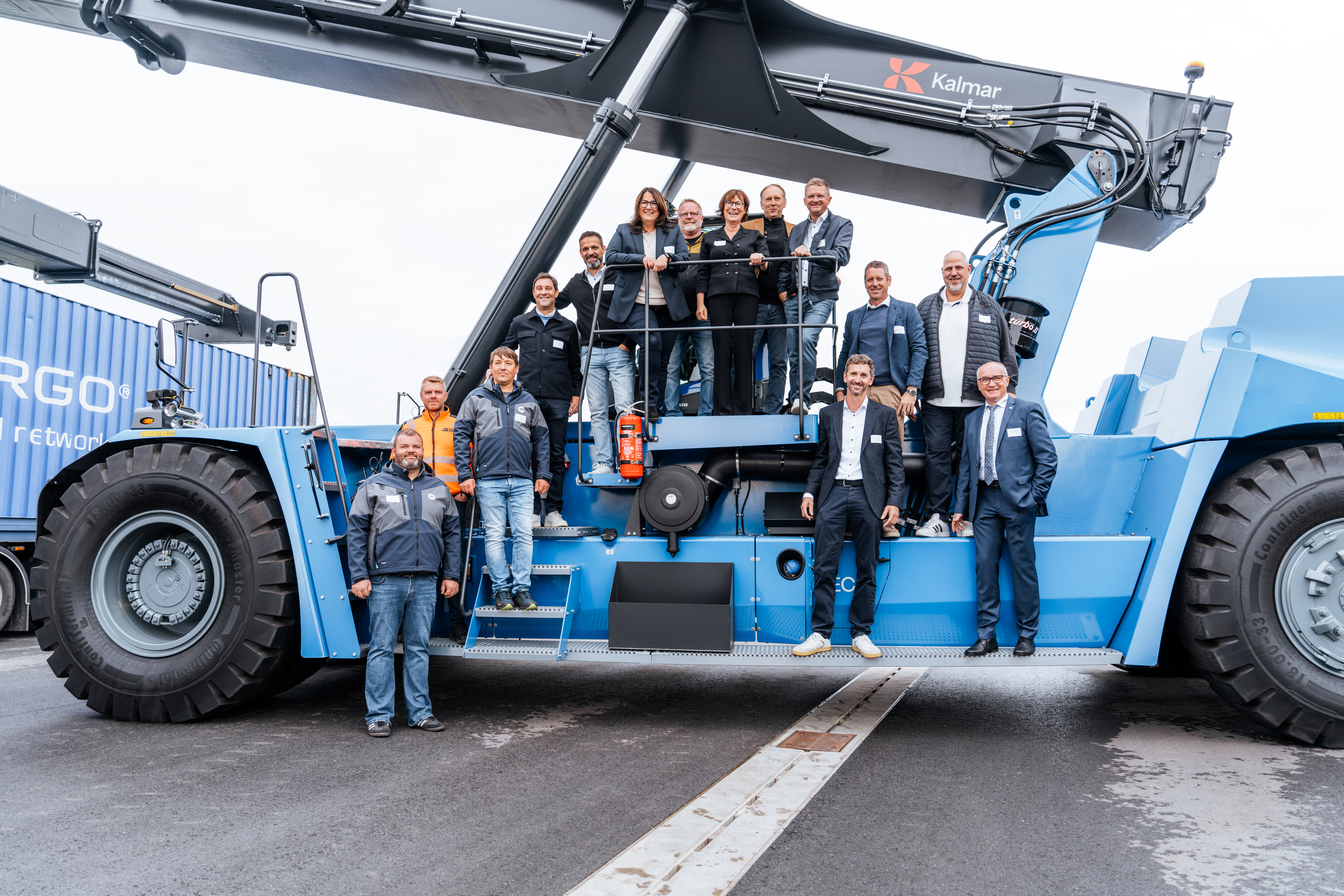 Gruppenfoto der geladenen Gäste auf dem Verladekran