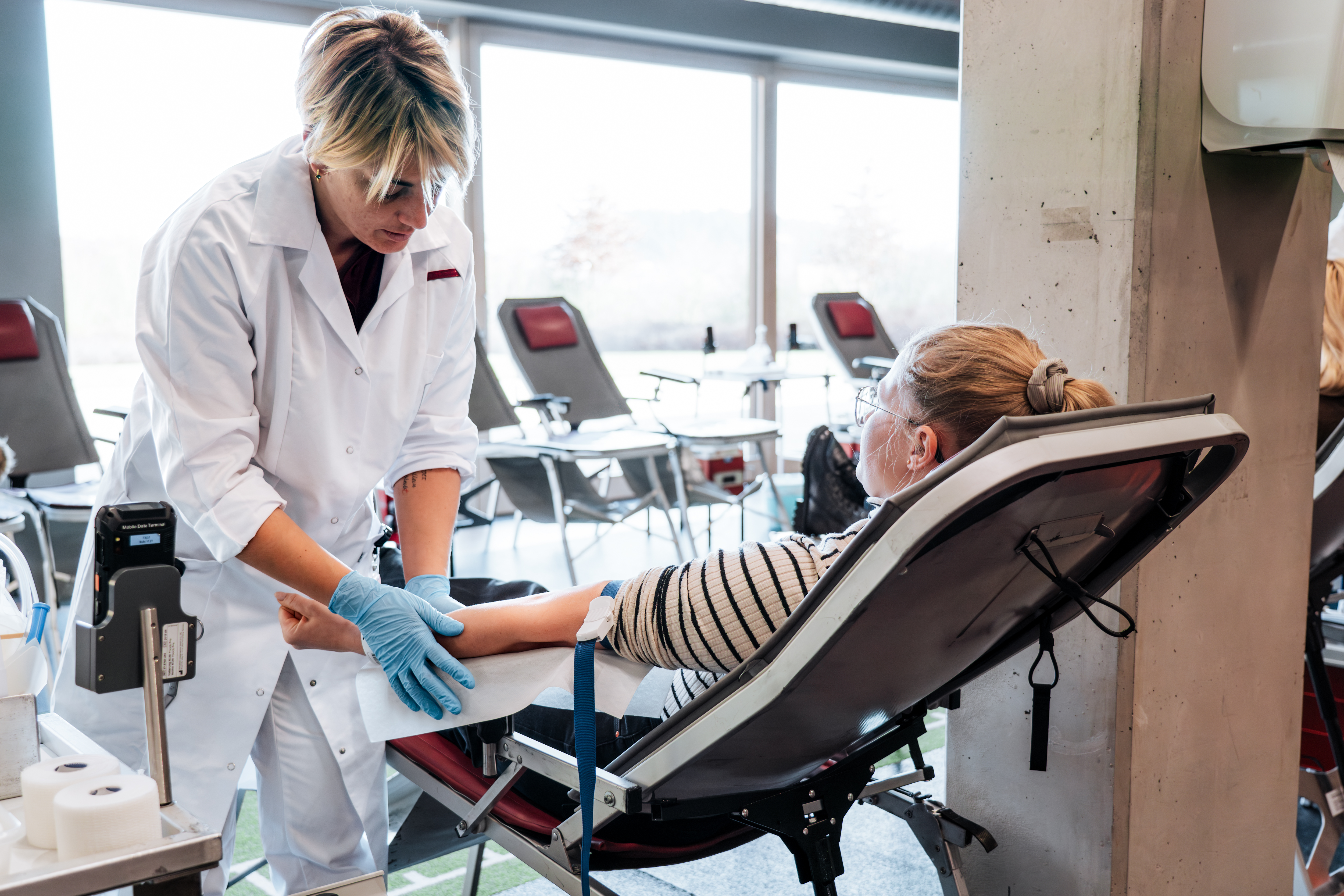 Eine Ärztin des BRK bereitet eine Spenderin für die Blutspende vor