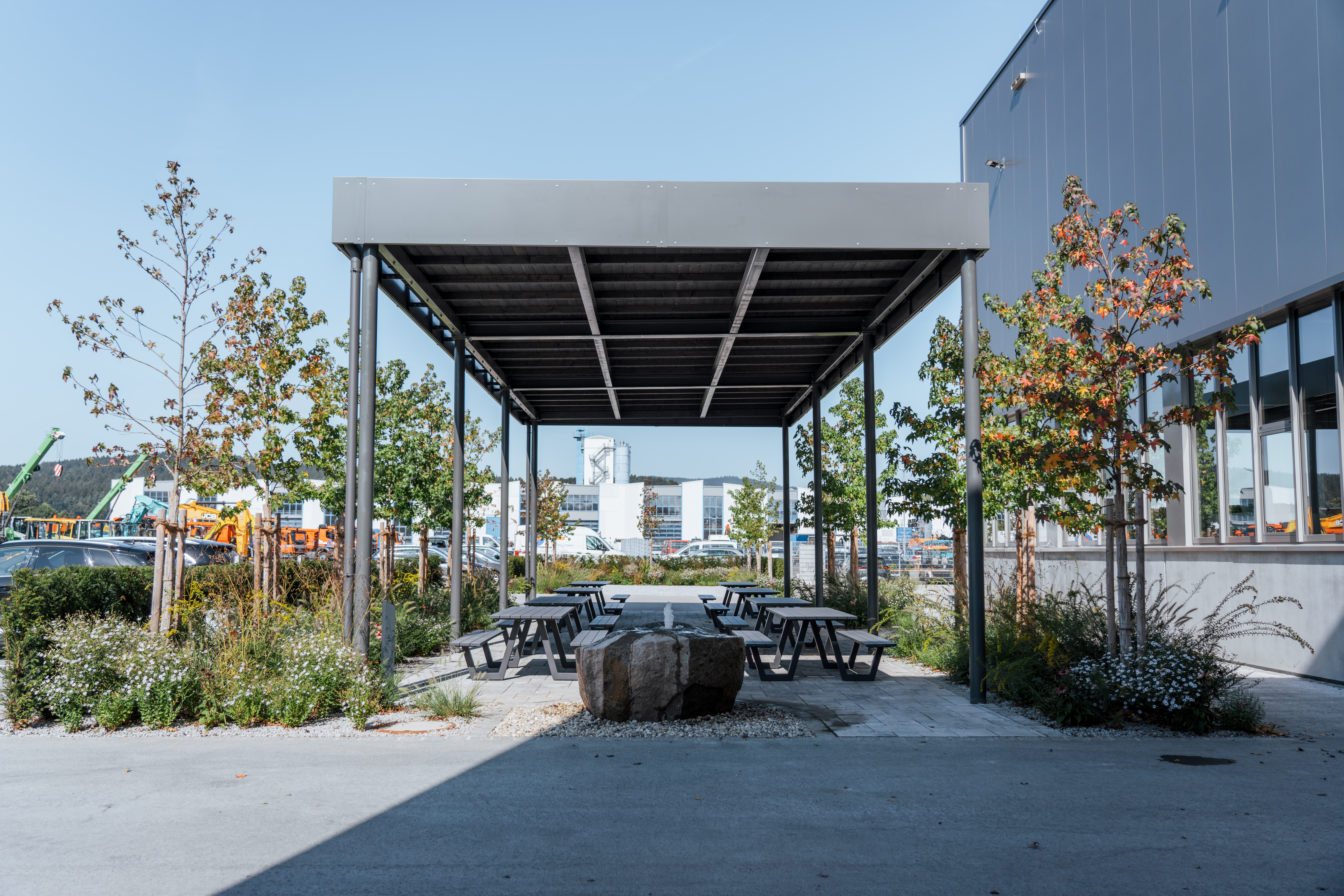 Sitzmöglichkeiten im Außenbereich des Werkstatt- und Logistikzentrums in Weiding, im Hintergrund die Lagerhallen
