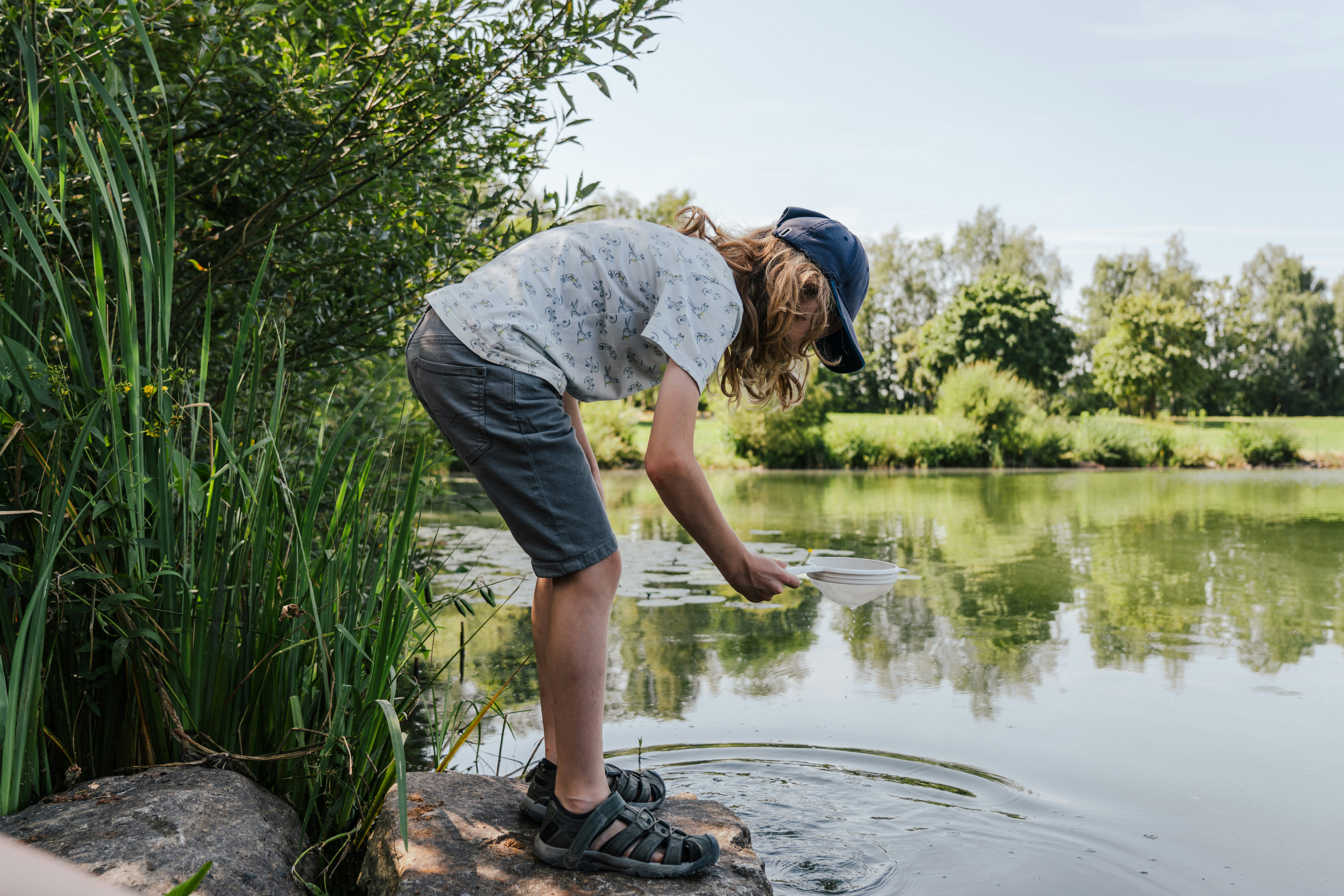 Kind am Ufer des Satzdorfer Sees mit Kescher