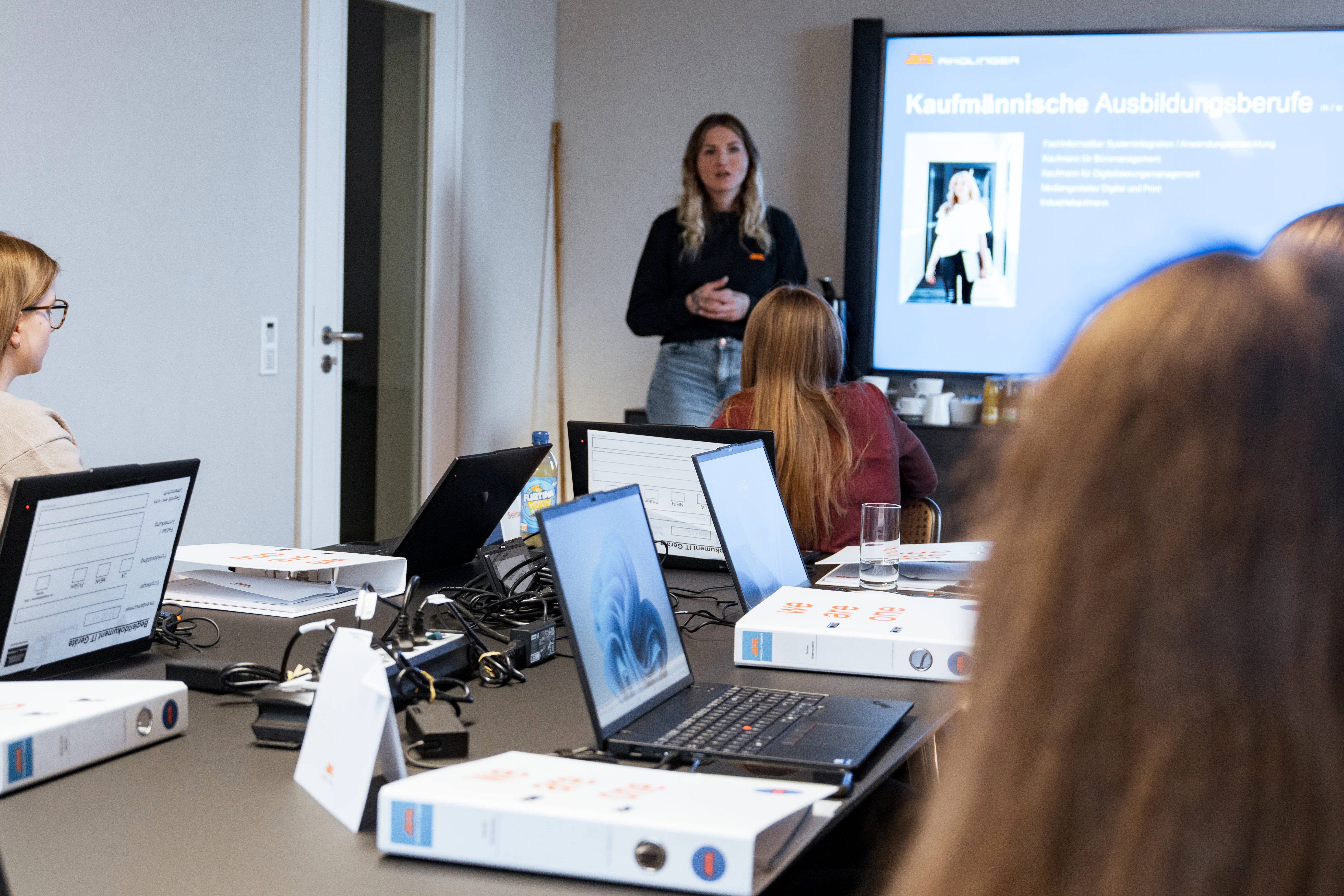 Im Besprechungsraum werden die kaufmännischen Ausbildungsberufe präsentiert. Die Praktikanten haben Laptops und Dokumentenordner auf dem Tisch