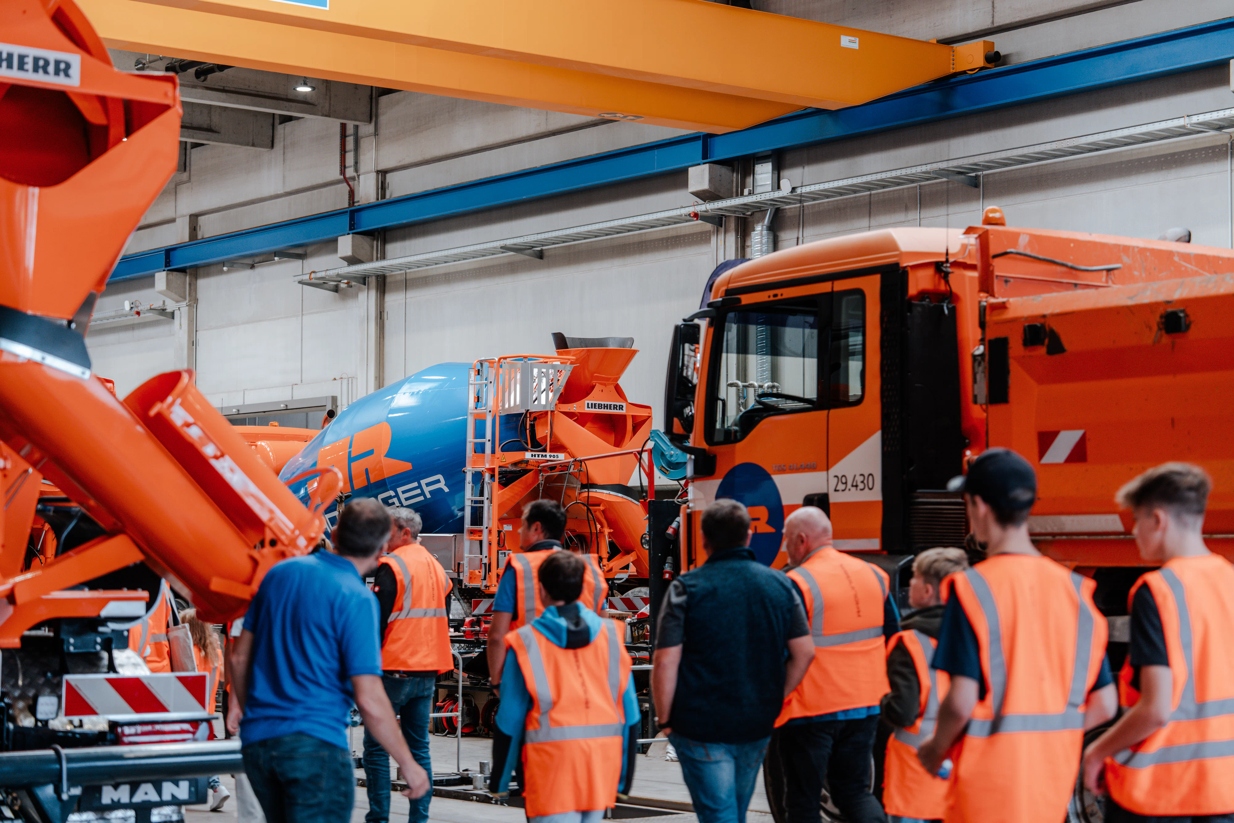 Interessierte bei der Führung durch die Werkstatt. Im Hintergrund diverse Baustellenfahrzeuge