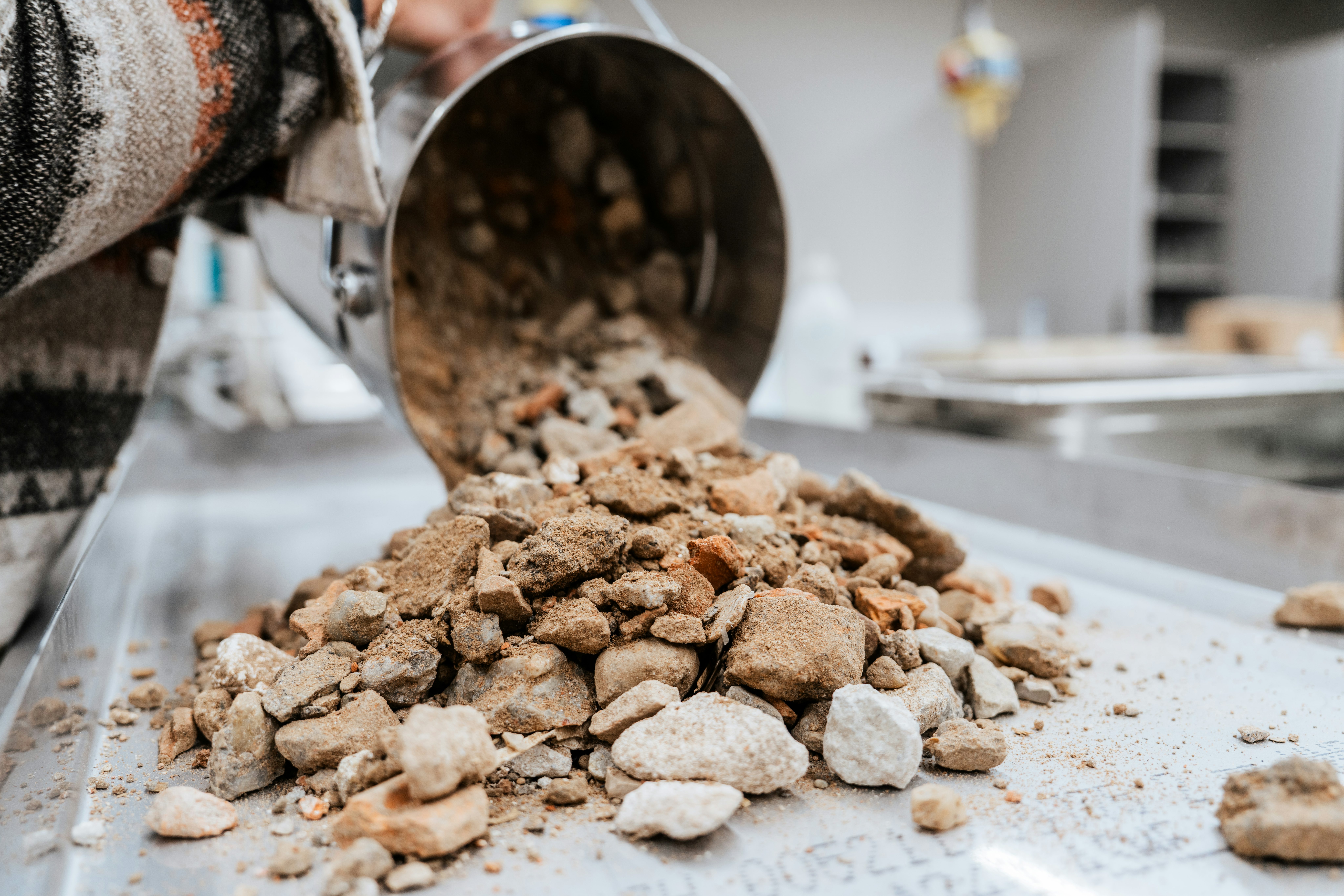 Gesteinsmischung wird zur weiteren Untersuchung auf dem Labortisch verteilt