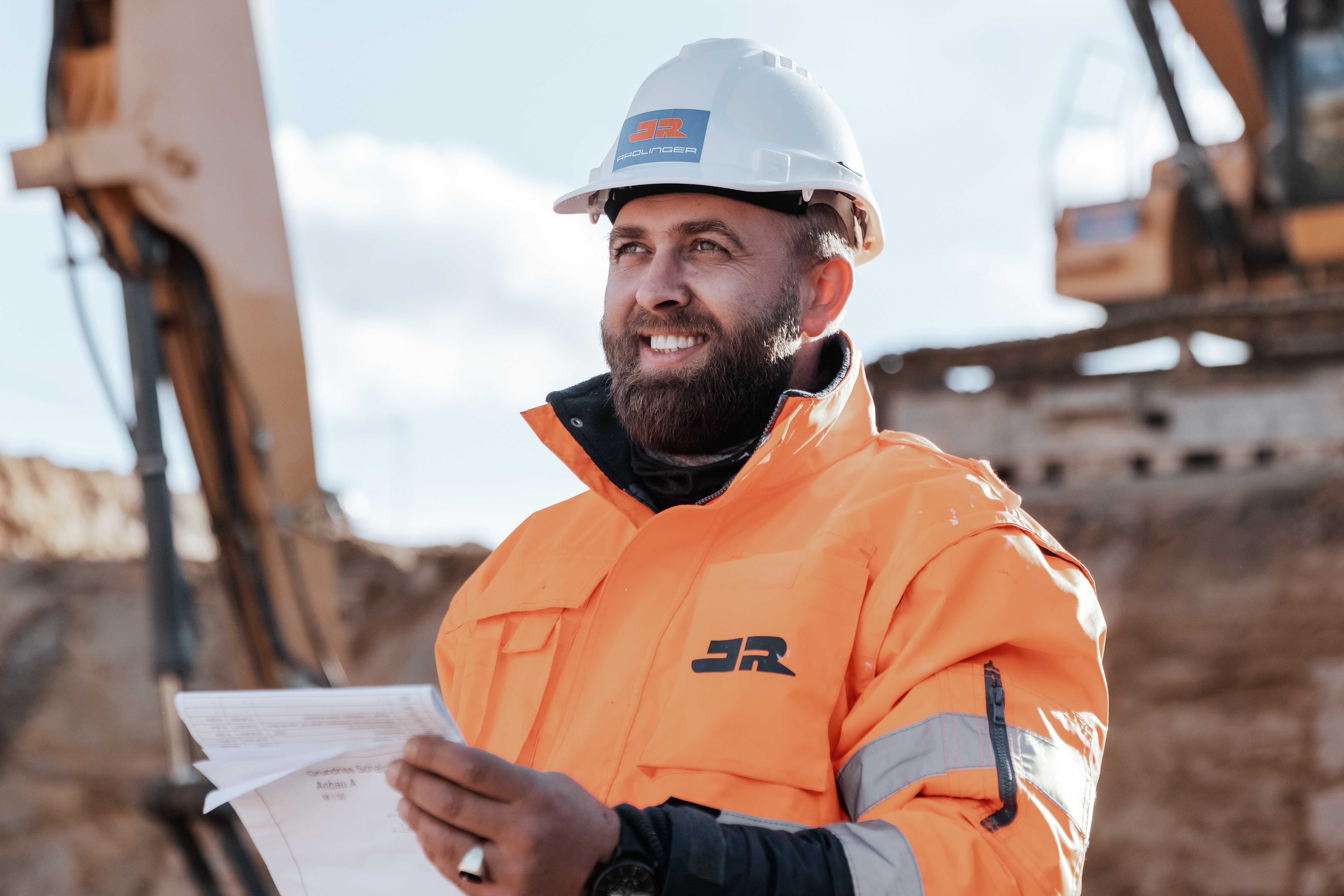 Vermessungstechniker bei Vermessung einer Baugrube auf einer Erdbaustelle der Josef Rädlinger Unternehmensgruppe