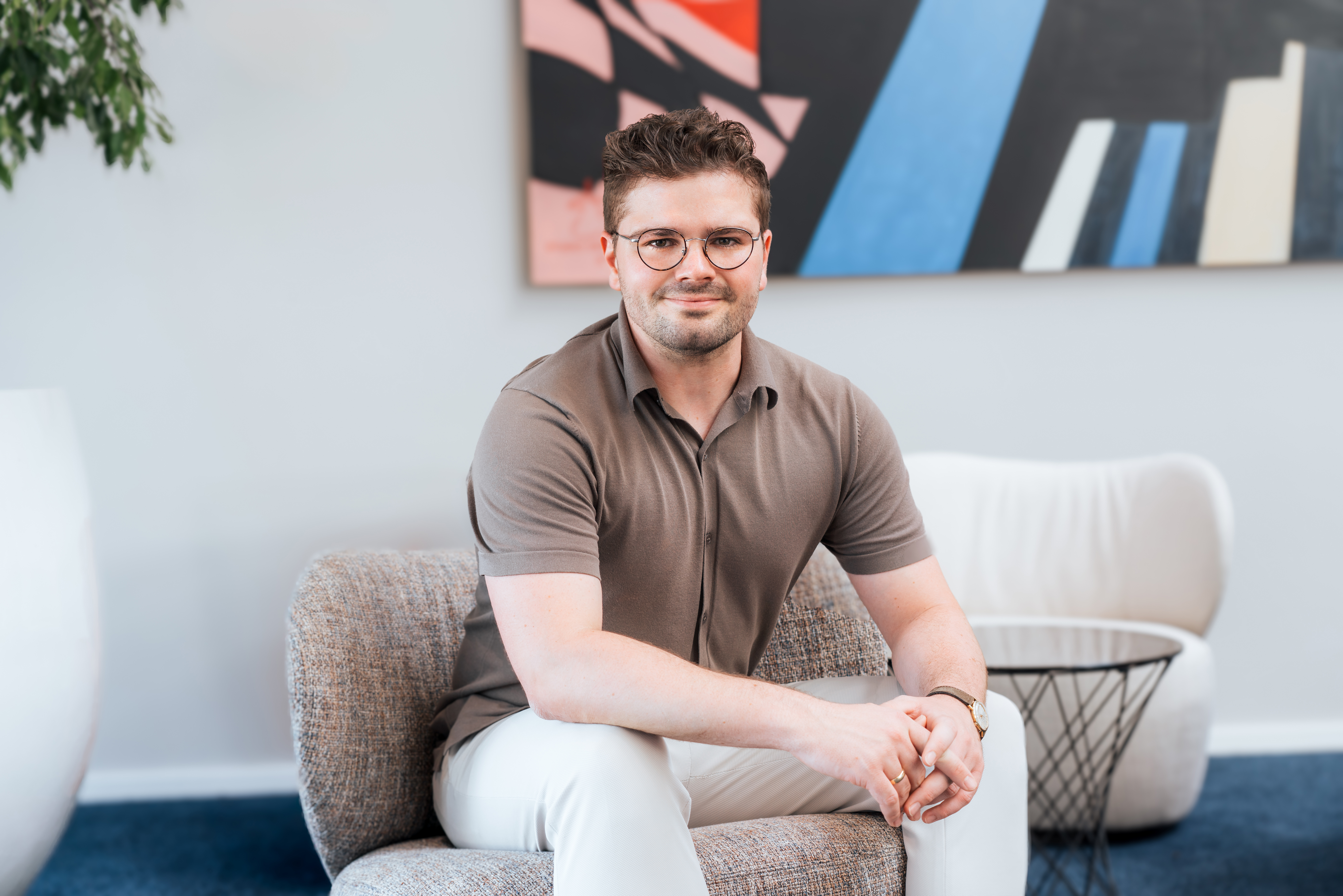 Portraitfoto von Luka Rädlinger, Teamleiter Personalentwicklung, sitzt auf einem Sessel im Eingangsbereich der Hauptverwaltung in Cham
