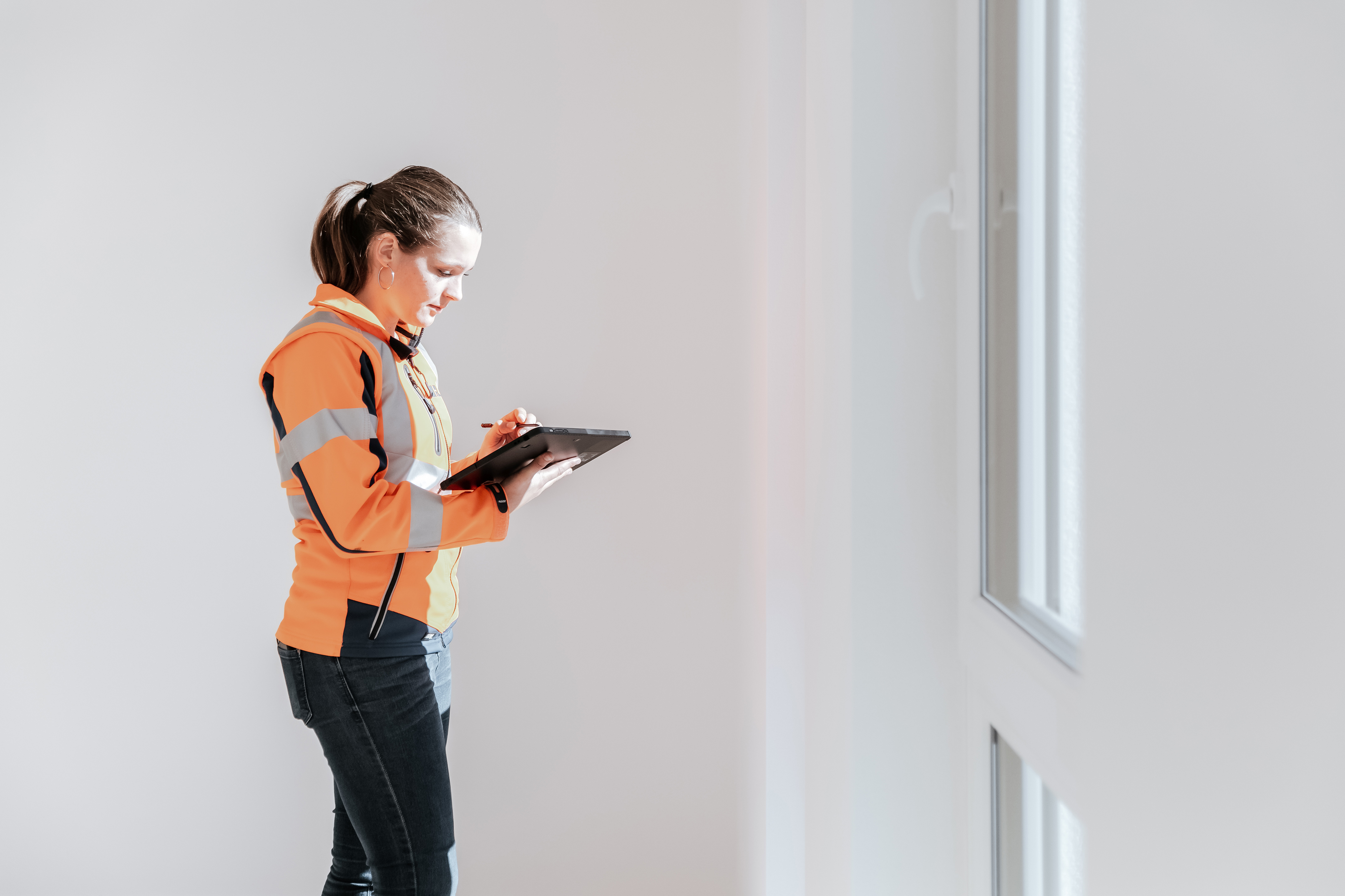 Petra, Bauleiterin im Rädlinger Hochbau, mit Tablet bei der Abnahme eines Wohngebäudes