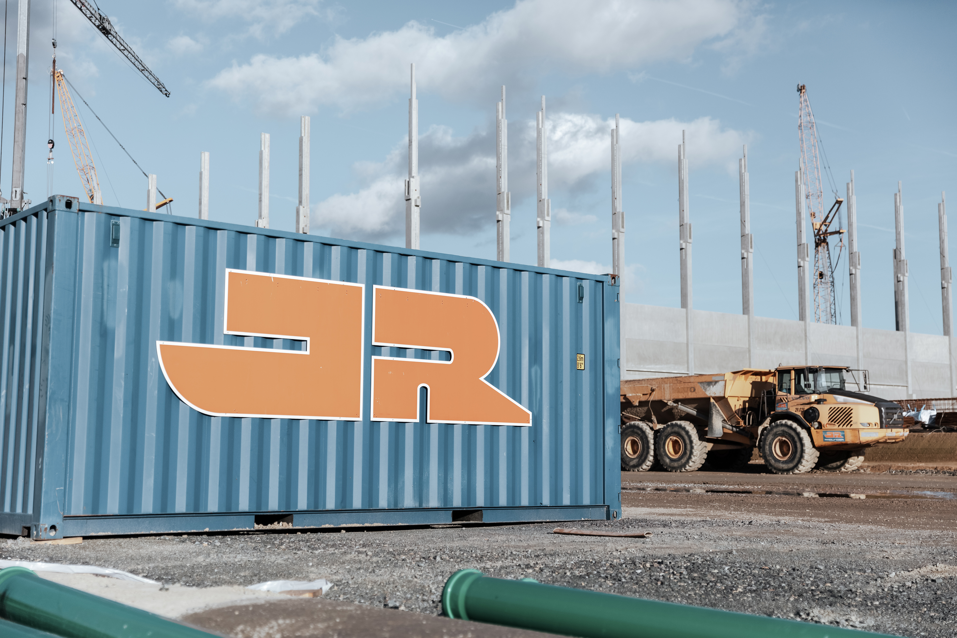 Rädlinger Container auf der Baustelle, daneben ein Dumper