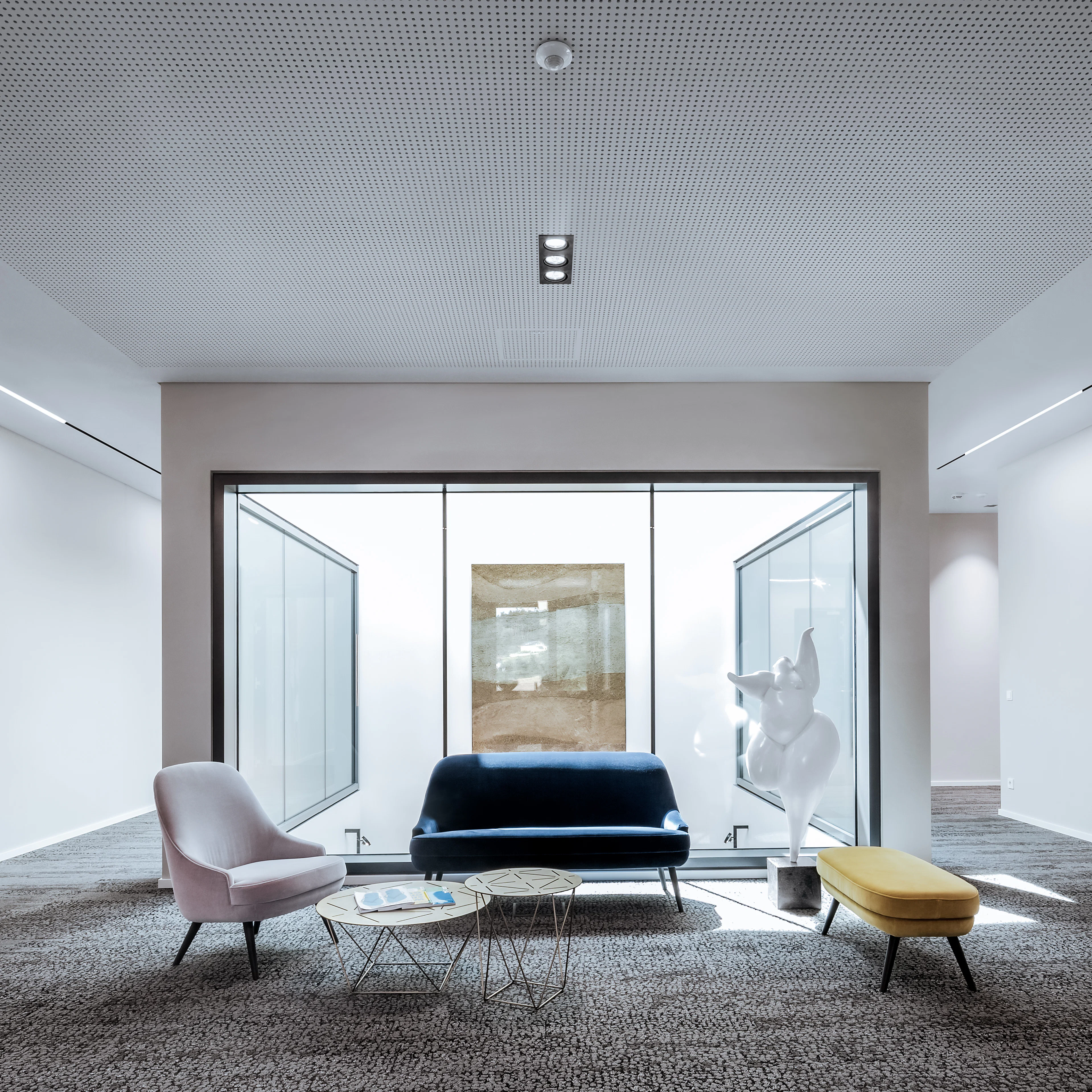 Moderne Sitzgruppe mit Couch und Sessel in der Rädlinger Hauptverwaltung in Cham, daneben eine Kunststatue