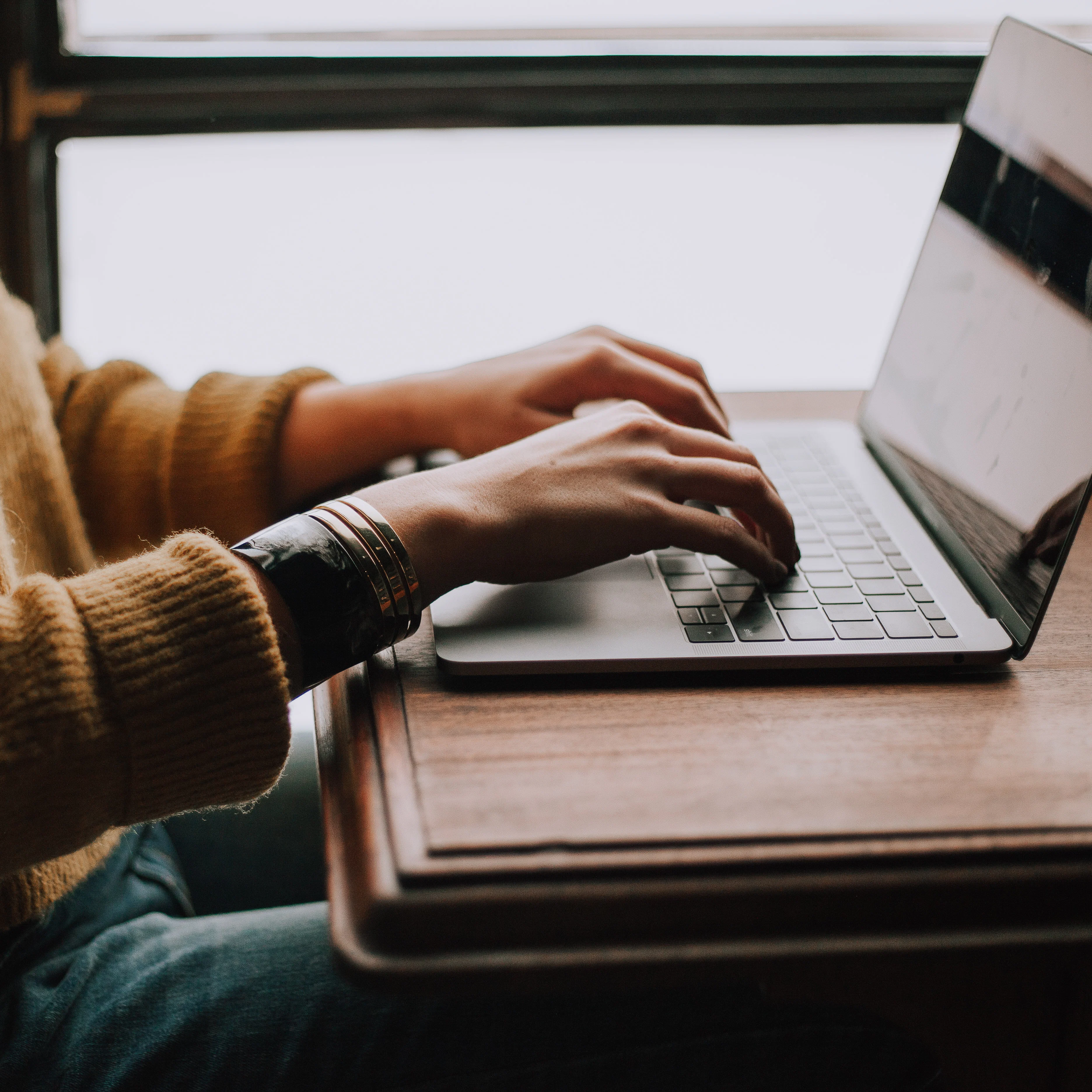 Student vor Laptop, Detailfoto von Händen auf Tastatur