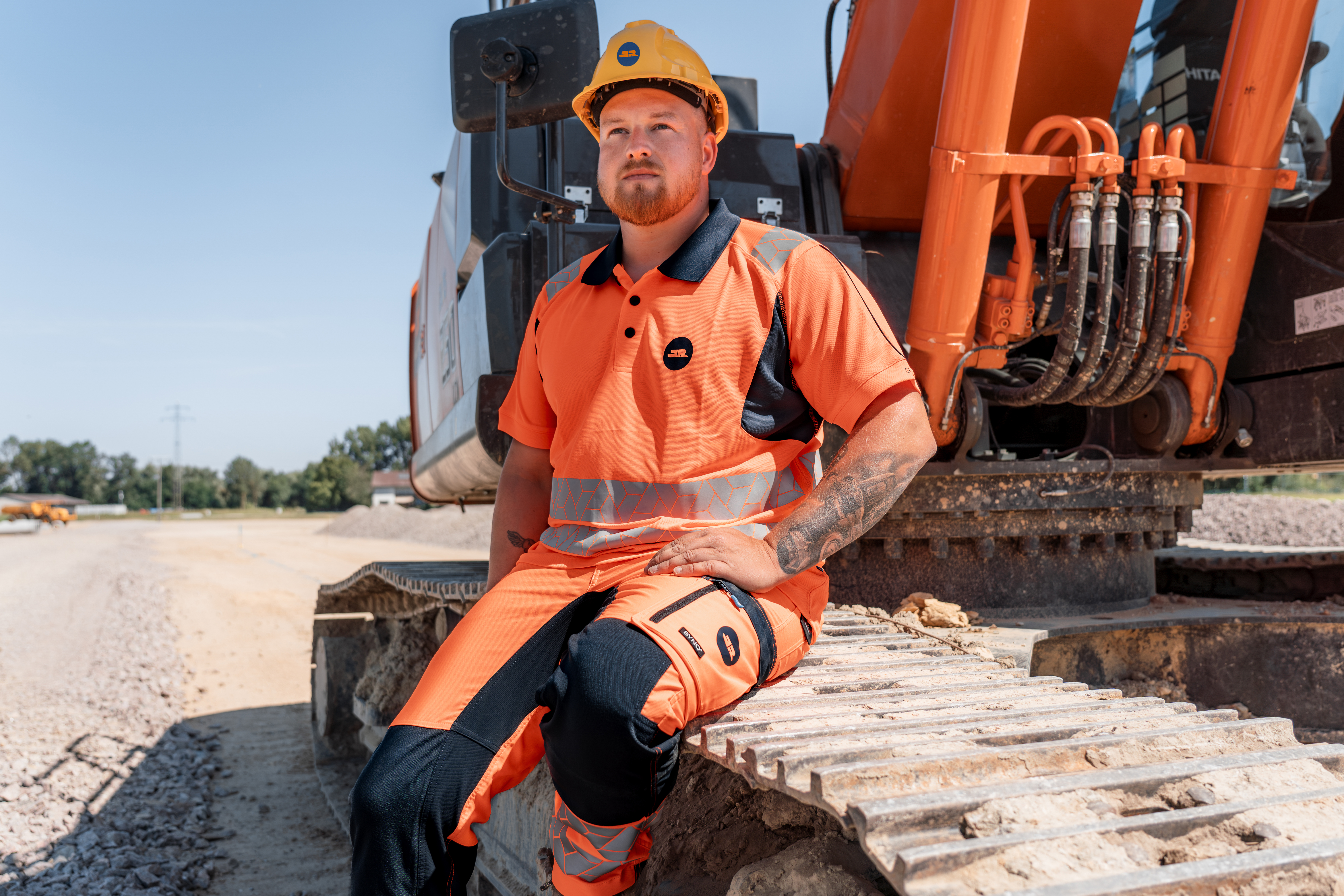 Bauarbeiter sitzt auf einem Kettenbagger auf einer Baustelle