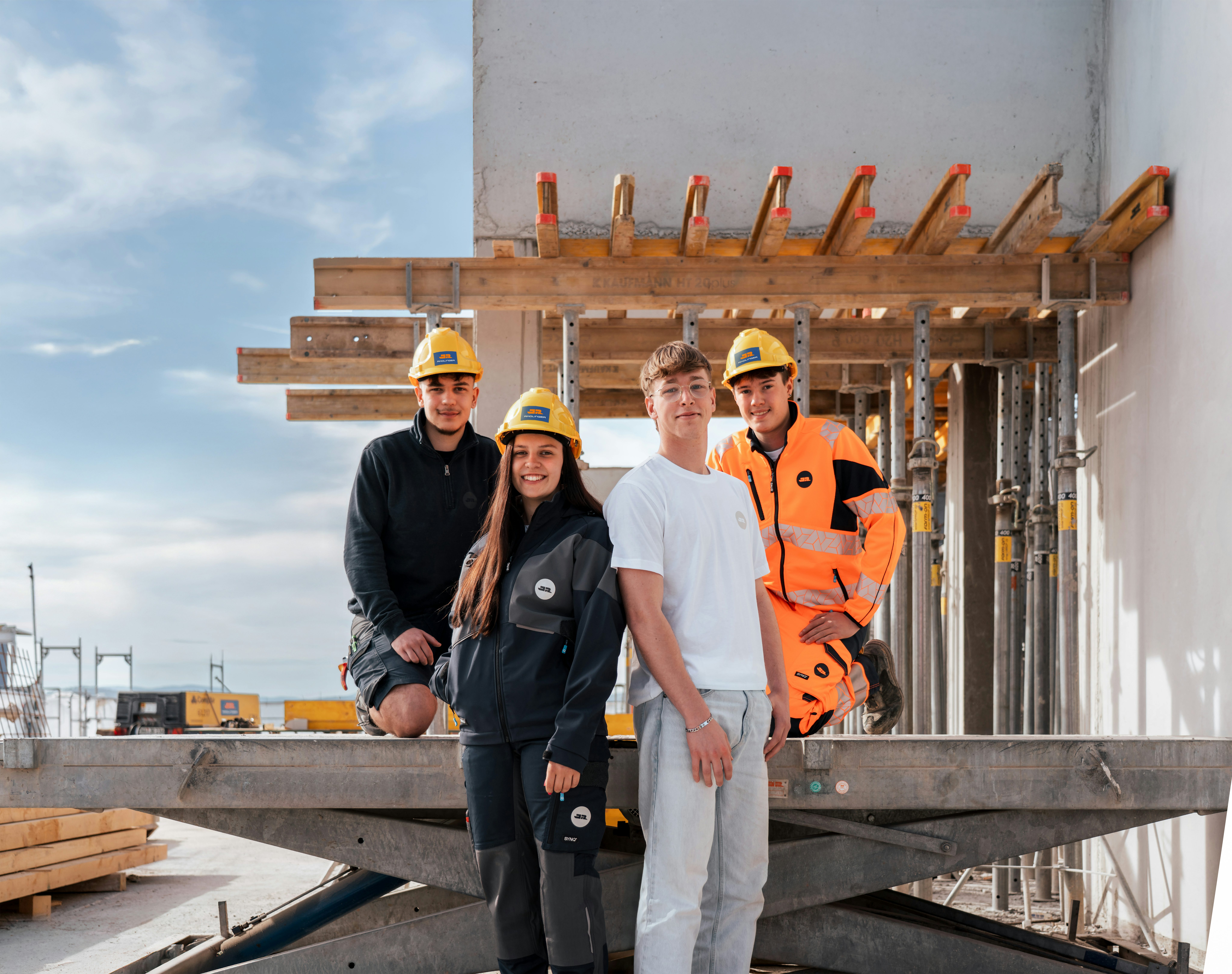 Gruppenfoto von vier Azubis auf einer Baustelle