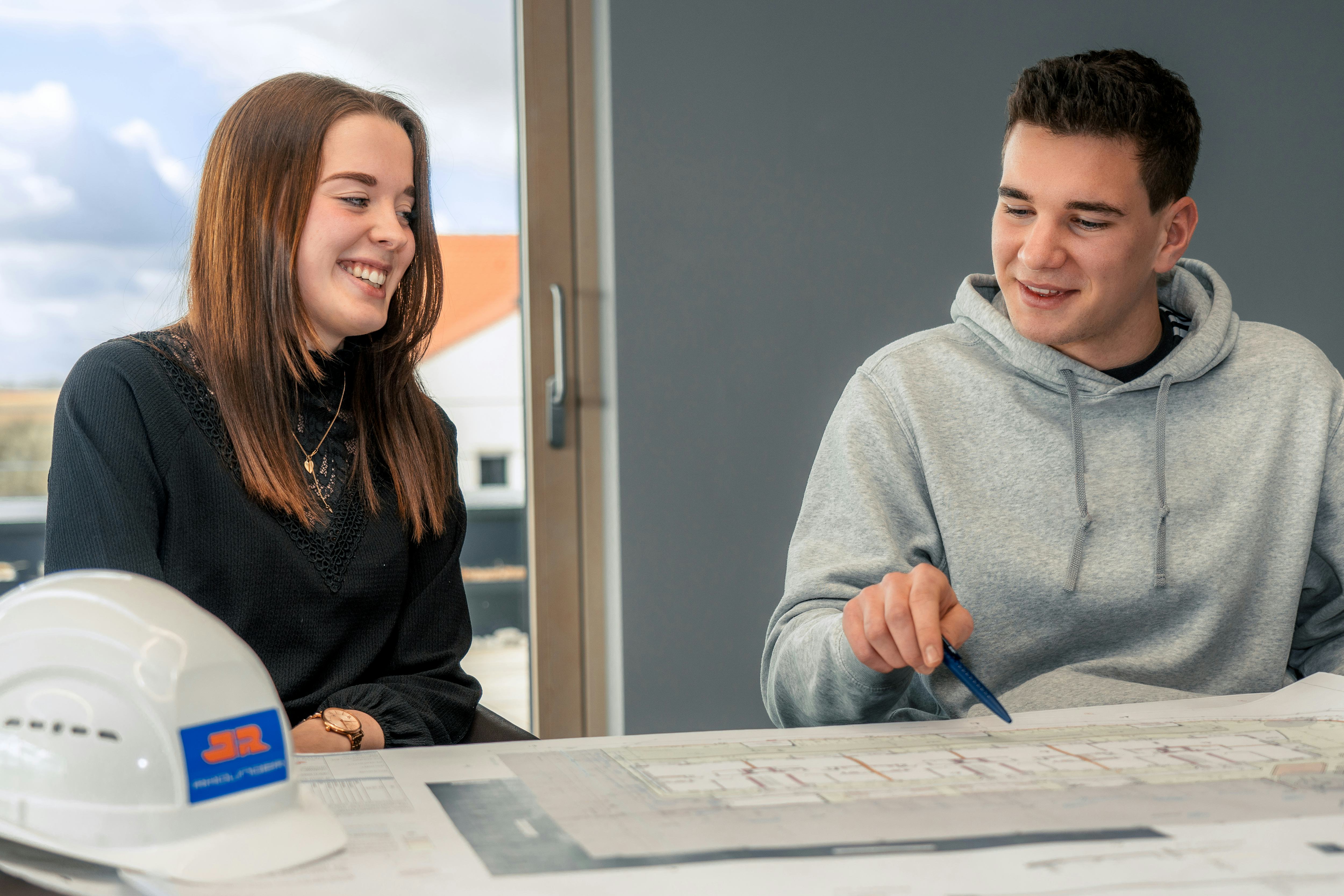 Zwei Studierende bei Rädlinger sehen sich Bauplan an