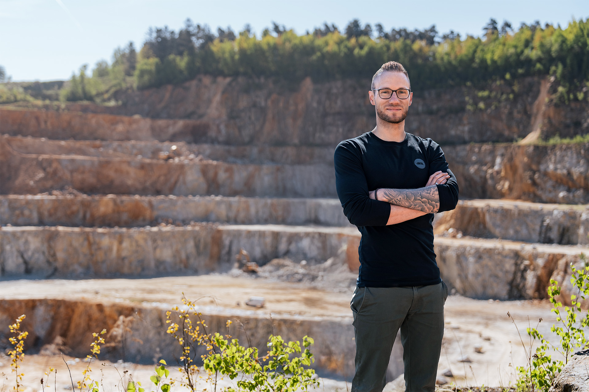 Portrait des Betriebsleiters des Steinbruchs Blauberg, im Hintergrund der Steinbruch
