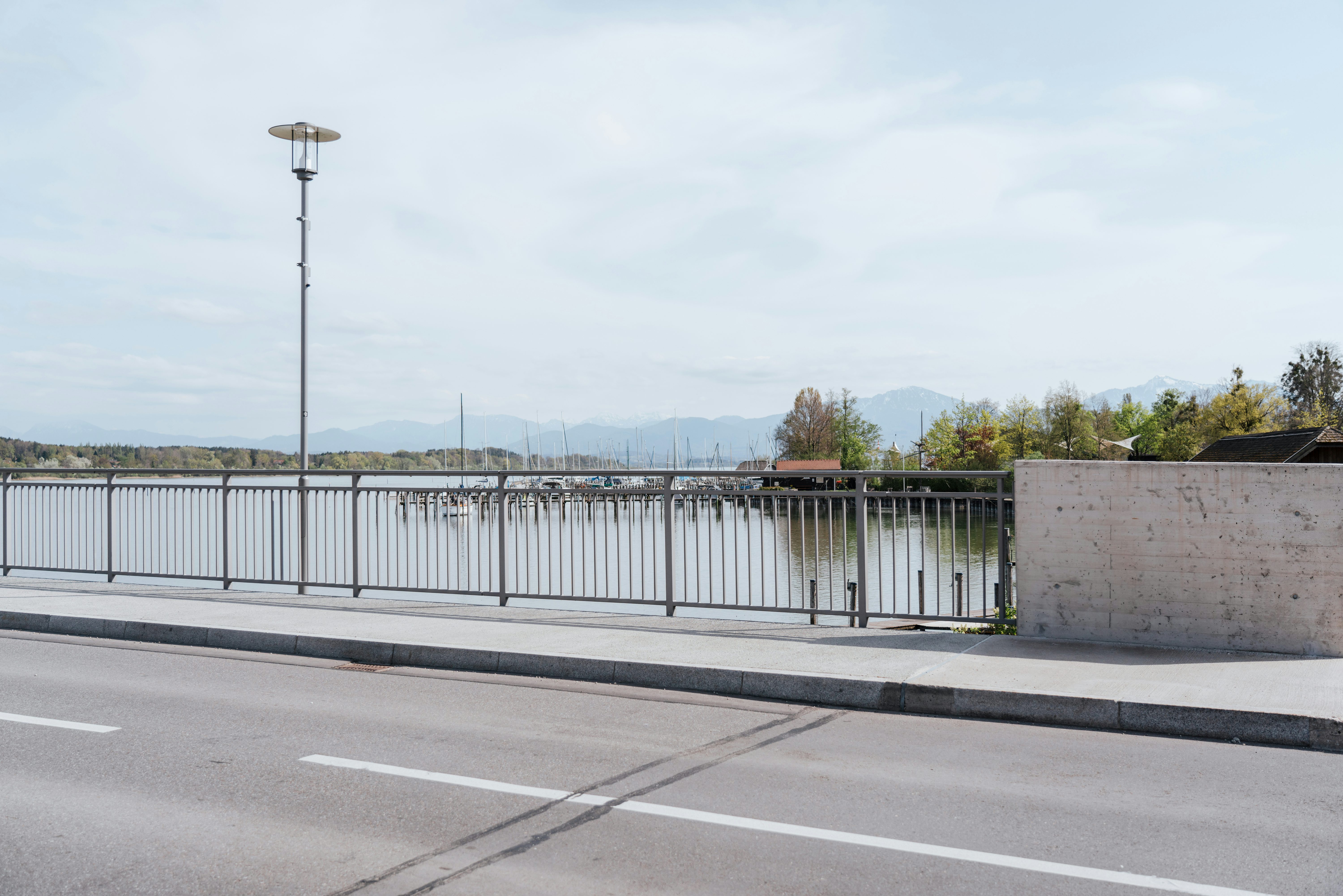 Neubau Alzbrücke Seebruck: die fertige Brücke mit Geländer und Blick auf den Chiemsee und die Chiemgauer Alpen
