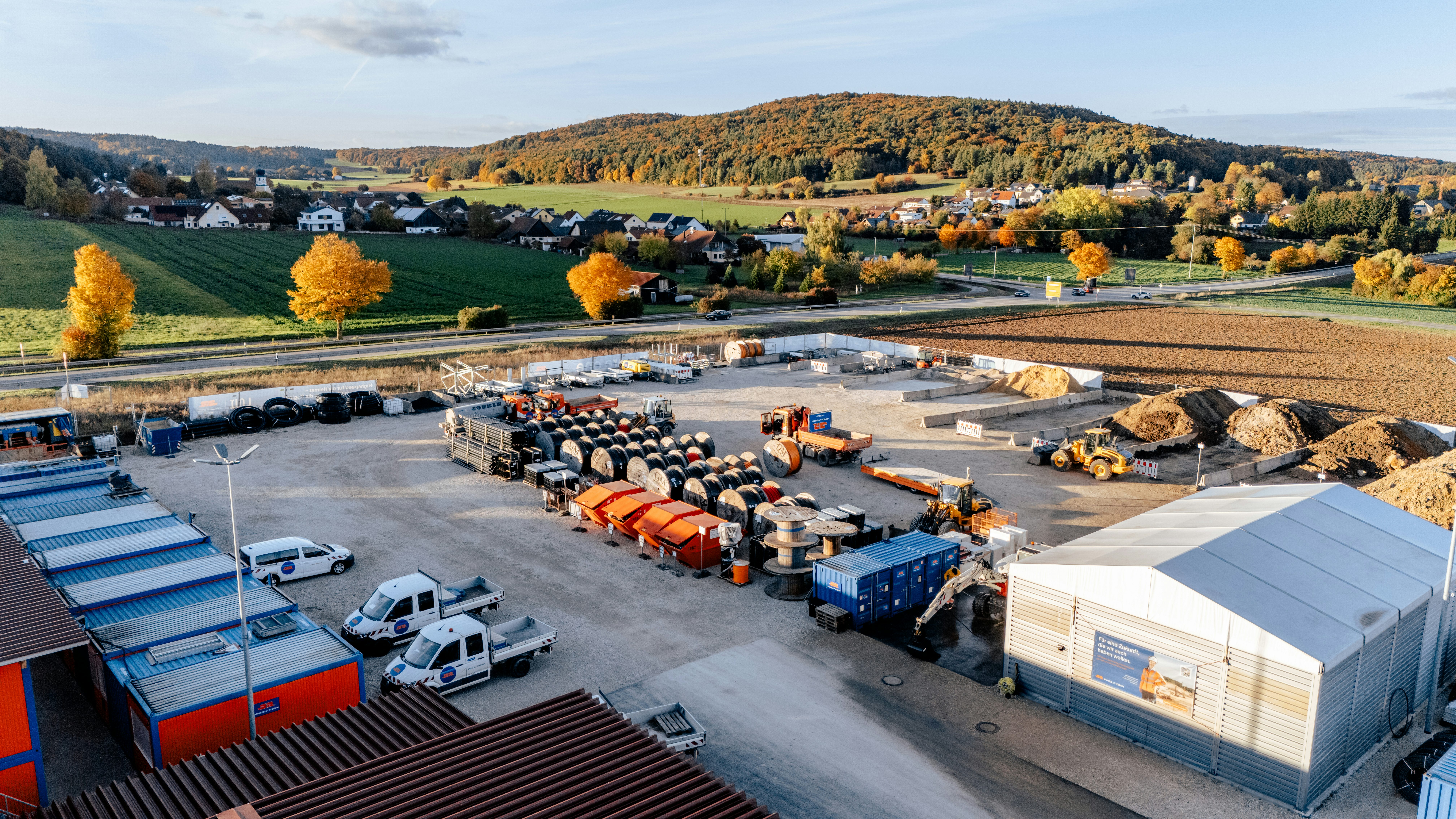 Drohnenaufnahme von einem Lager mit verschiedensten Maschinen und Kabeln für den Breitbandausbau im Landkreis Regensburg und Neumarkt
