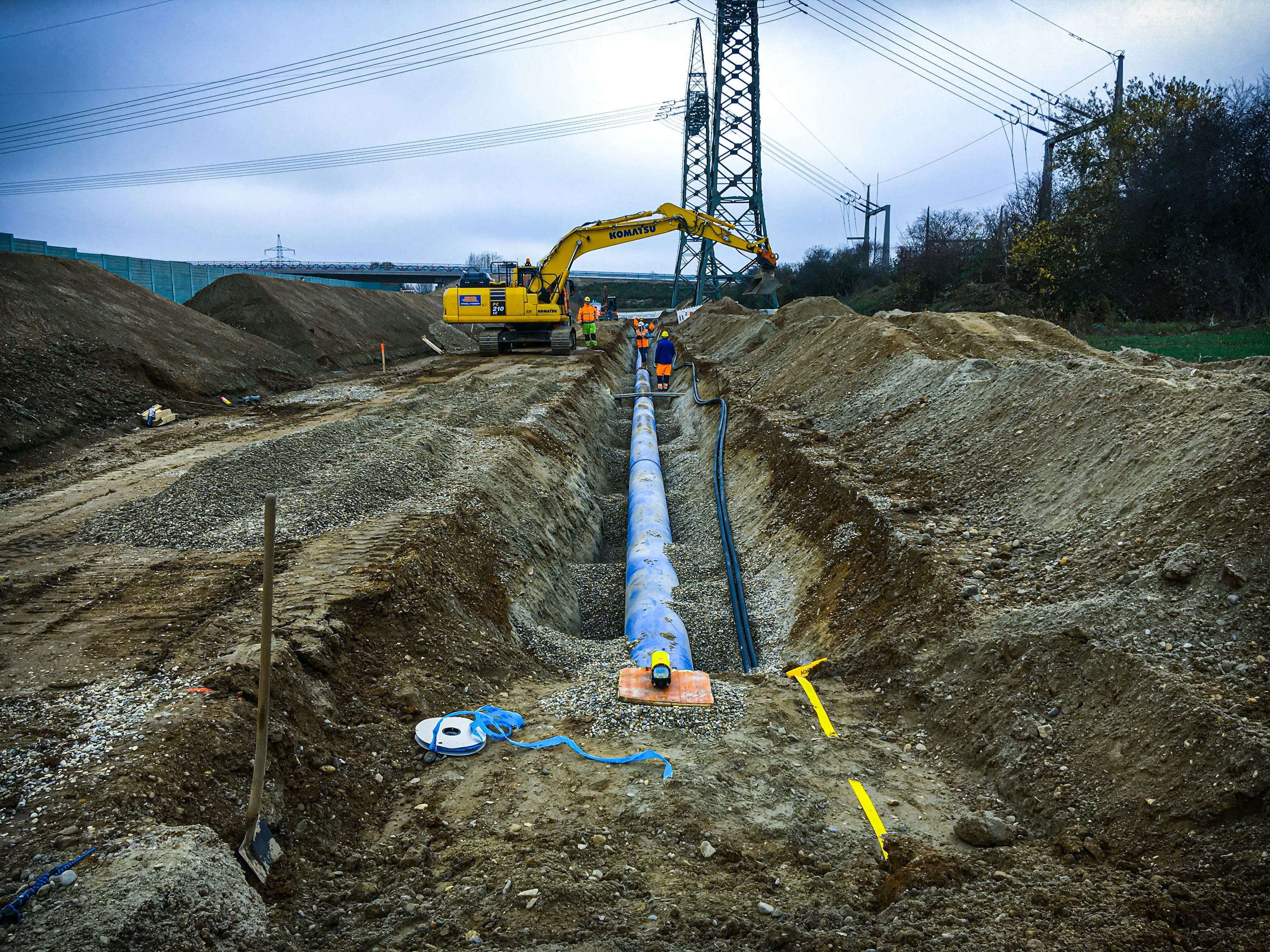 Bagger beim Verfüllen eines Grabens, in dem eine Wasserleitung liegt