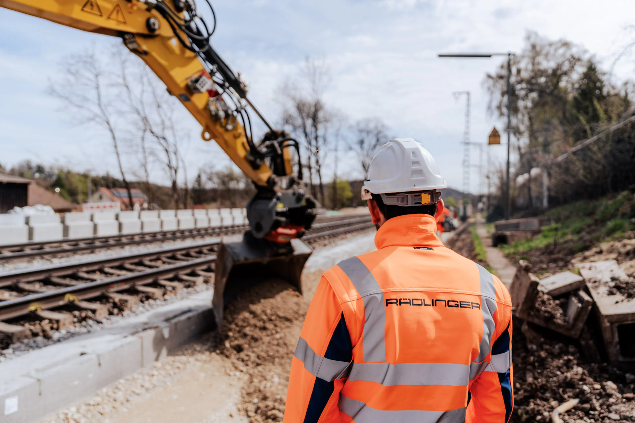 Gleisarbeiten mit Zweiwegebagger und Mitarbeiter des Josef Rädlinger Bahnbaus