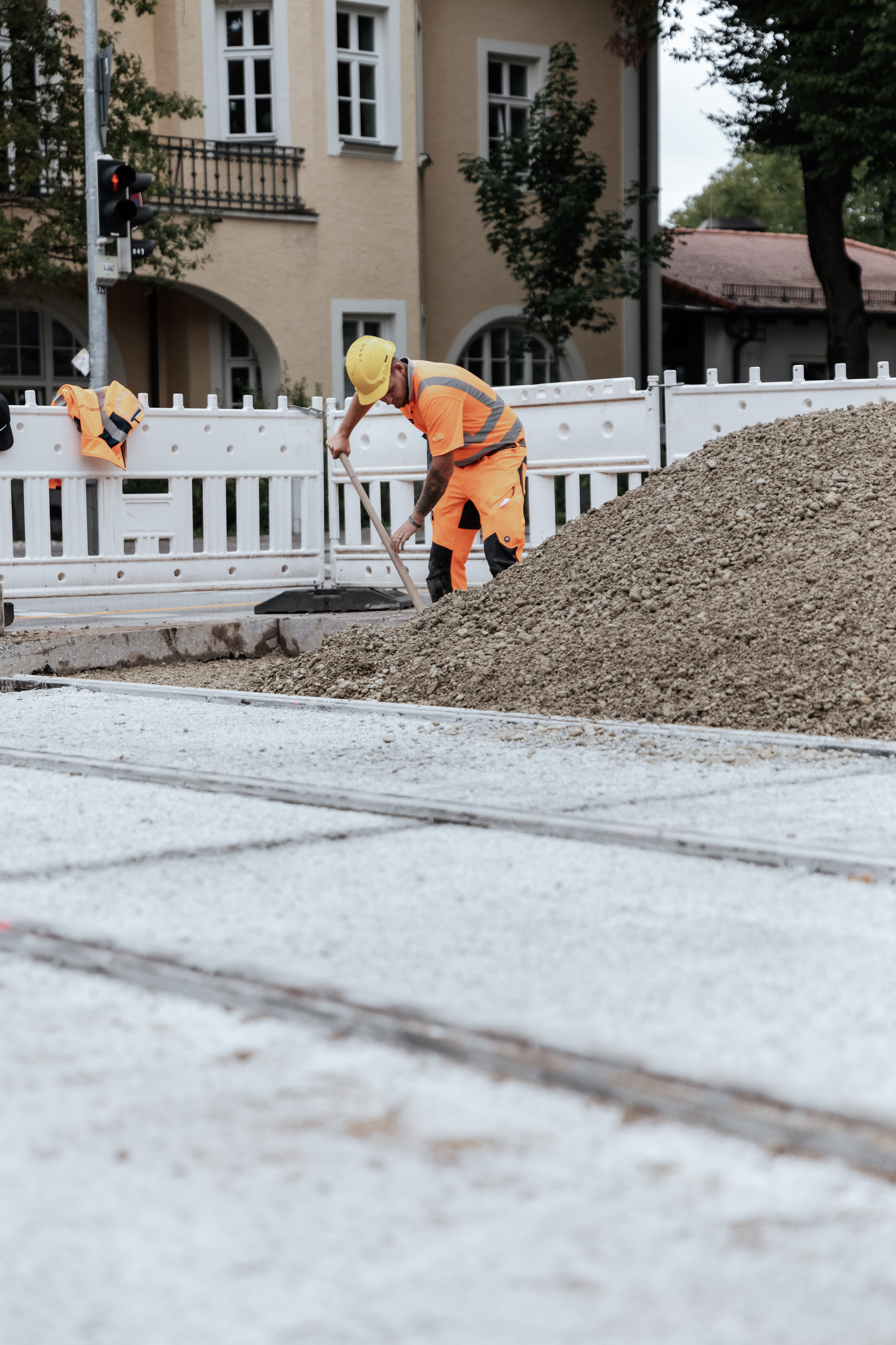 Tramstrecke 25 München: JR Mitarbeiter schaufelt Frostschutz