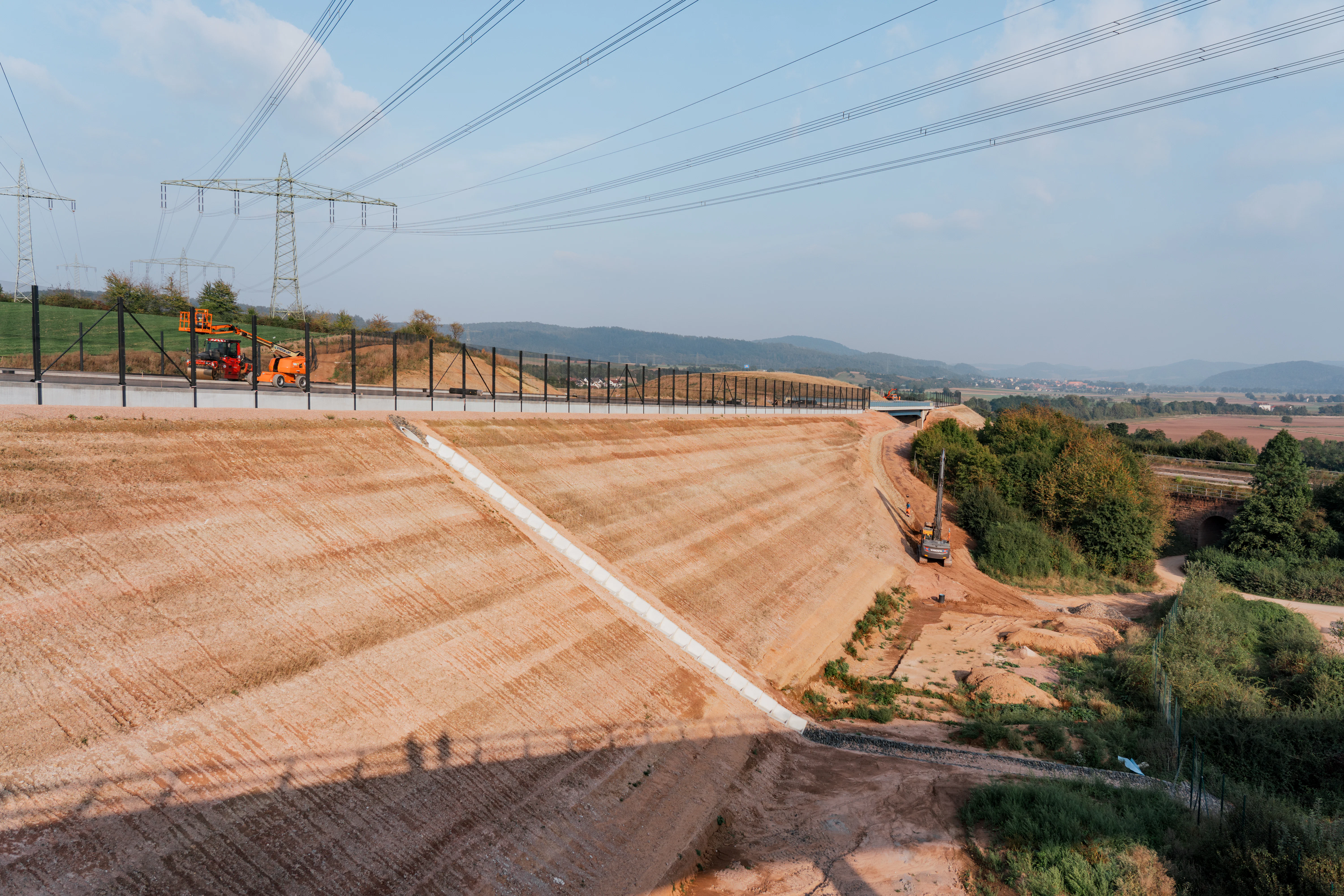 Neubau der A44 bei Wommen:  Erdarbeiten an einer Böschung, entlang der Autobahn verläuft ein Tierschutzzaun