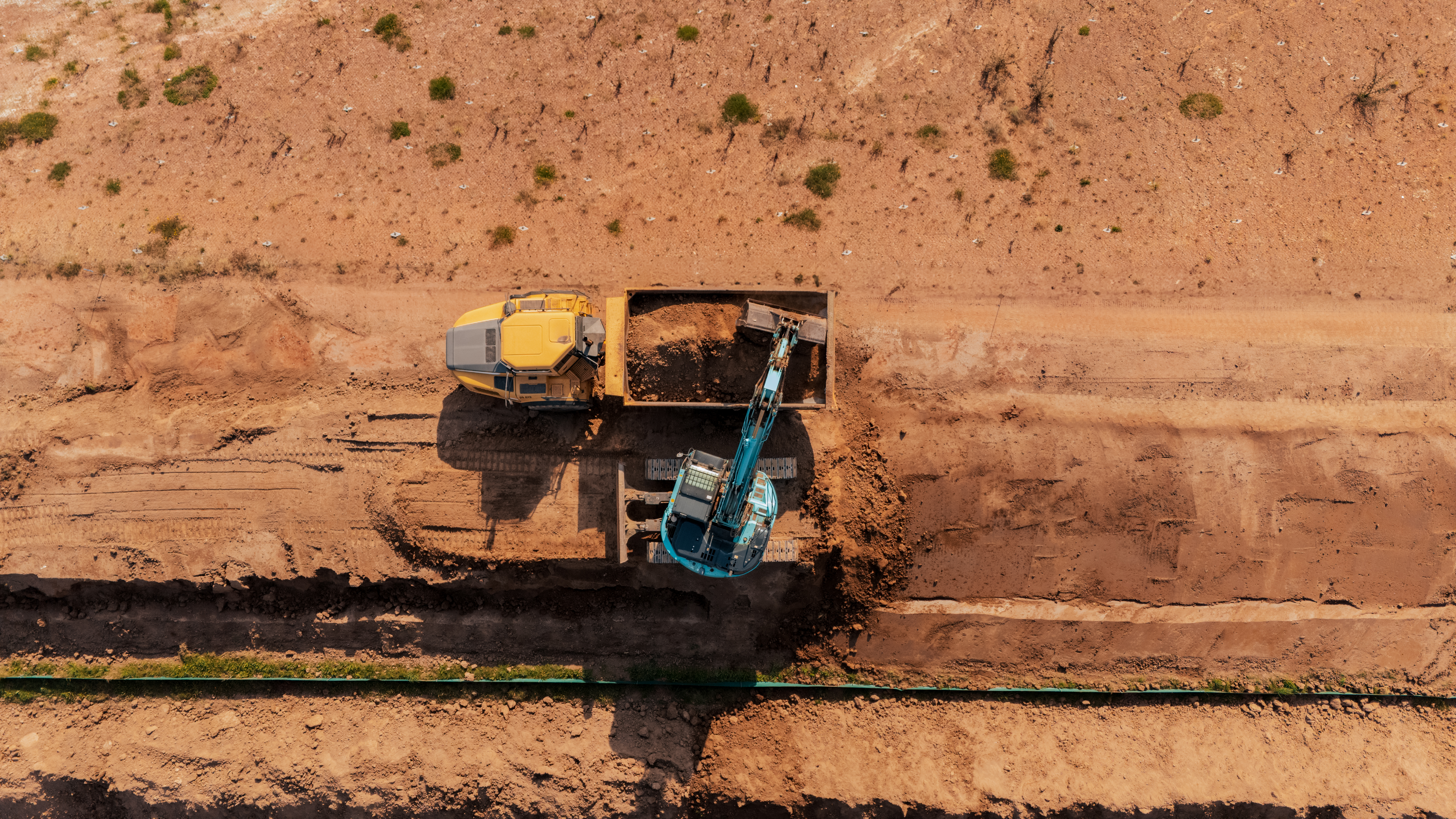 Neubau der A44 bei Wommen: Bagger verlädt abgetragenes Erdreich auf einen Dumper