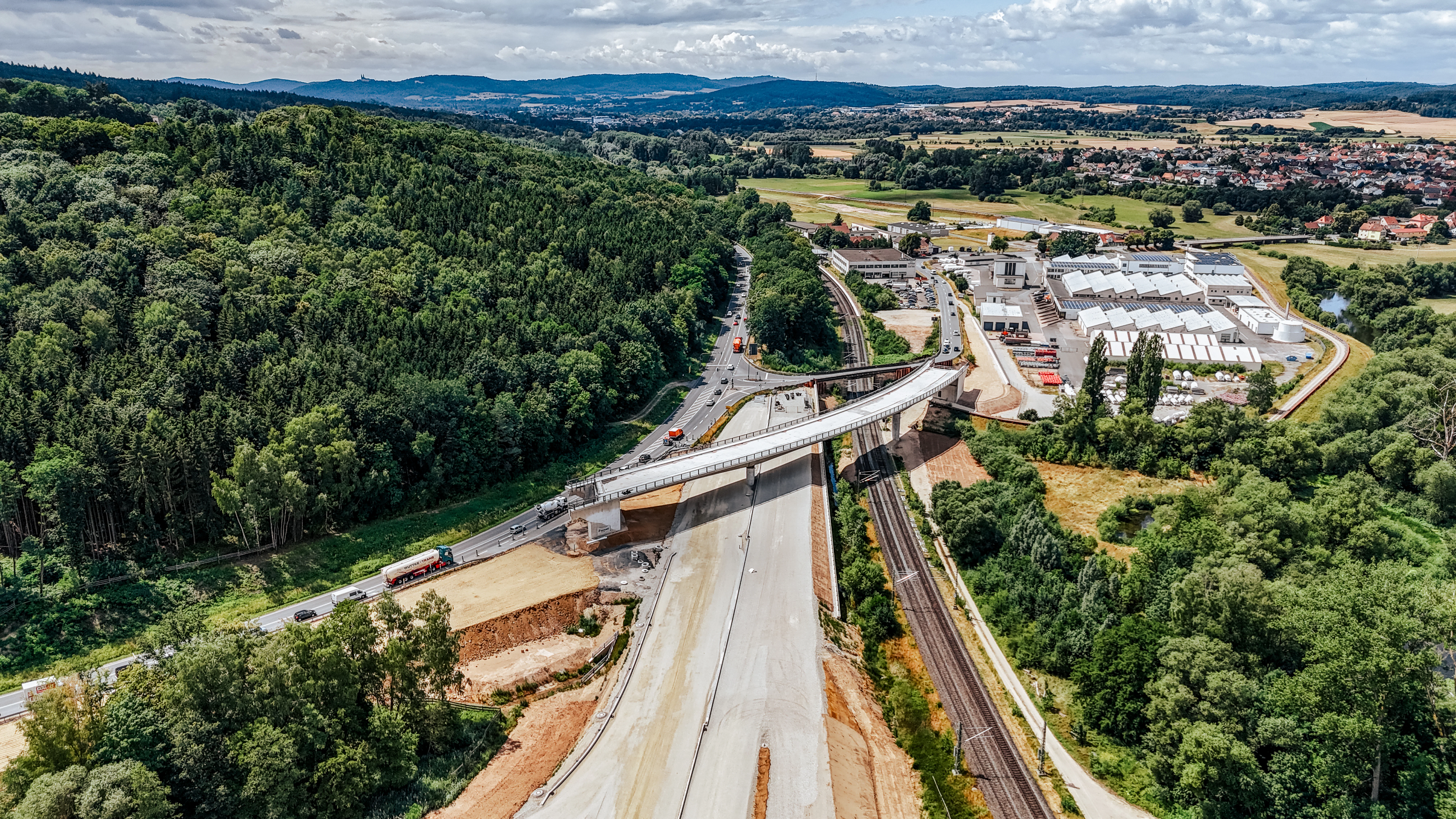 Drohnenaufnahme des Neubaus der B173 mit einer Brücke und Wald im Hintergrund