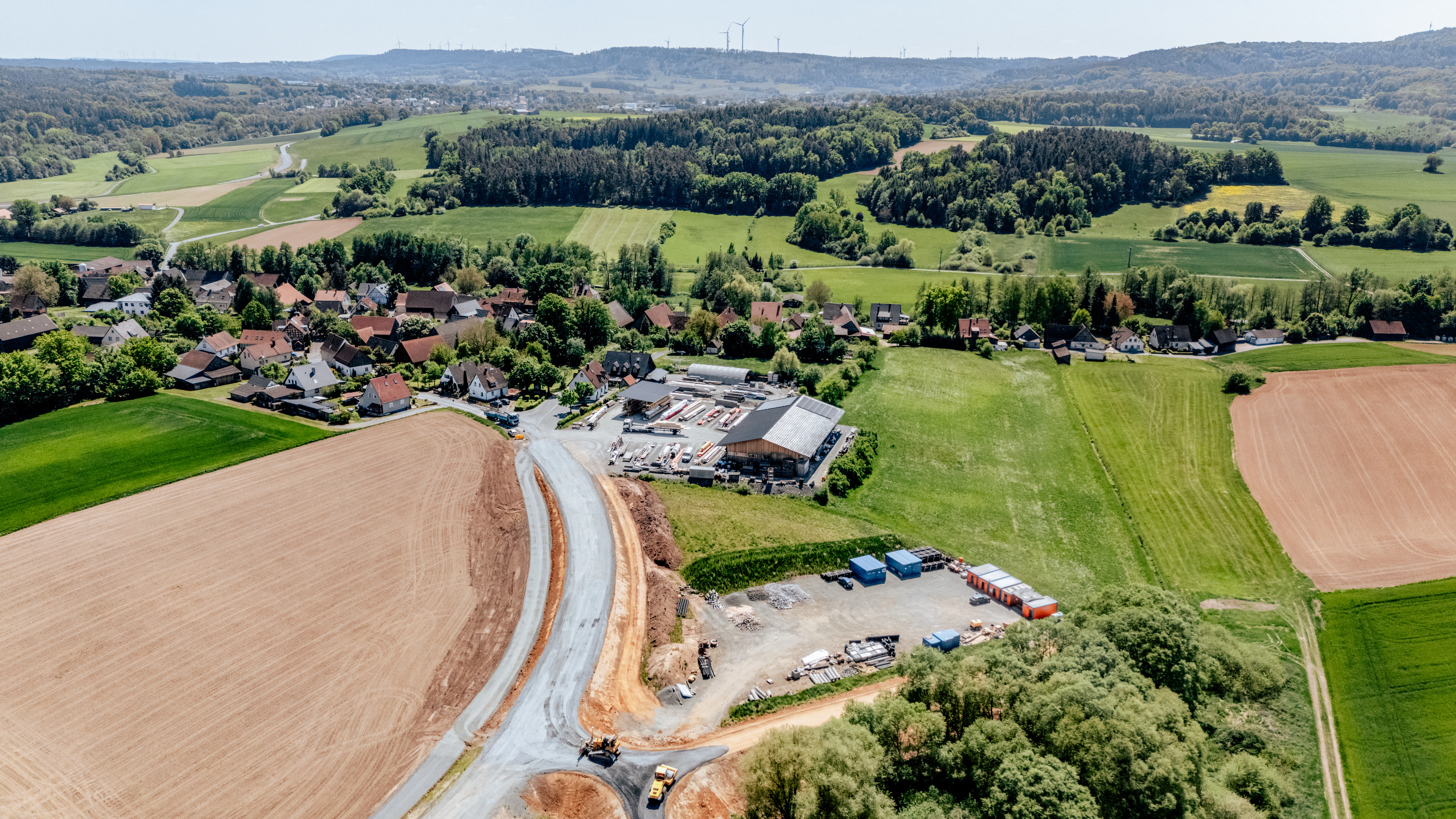 Drohnenaufnahme der Baustelle der Ortsumfahrung Döllnitz mir einem Dorf im Hintergrund