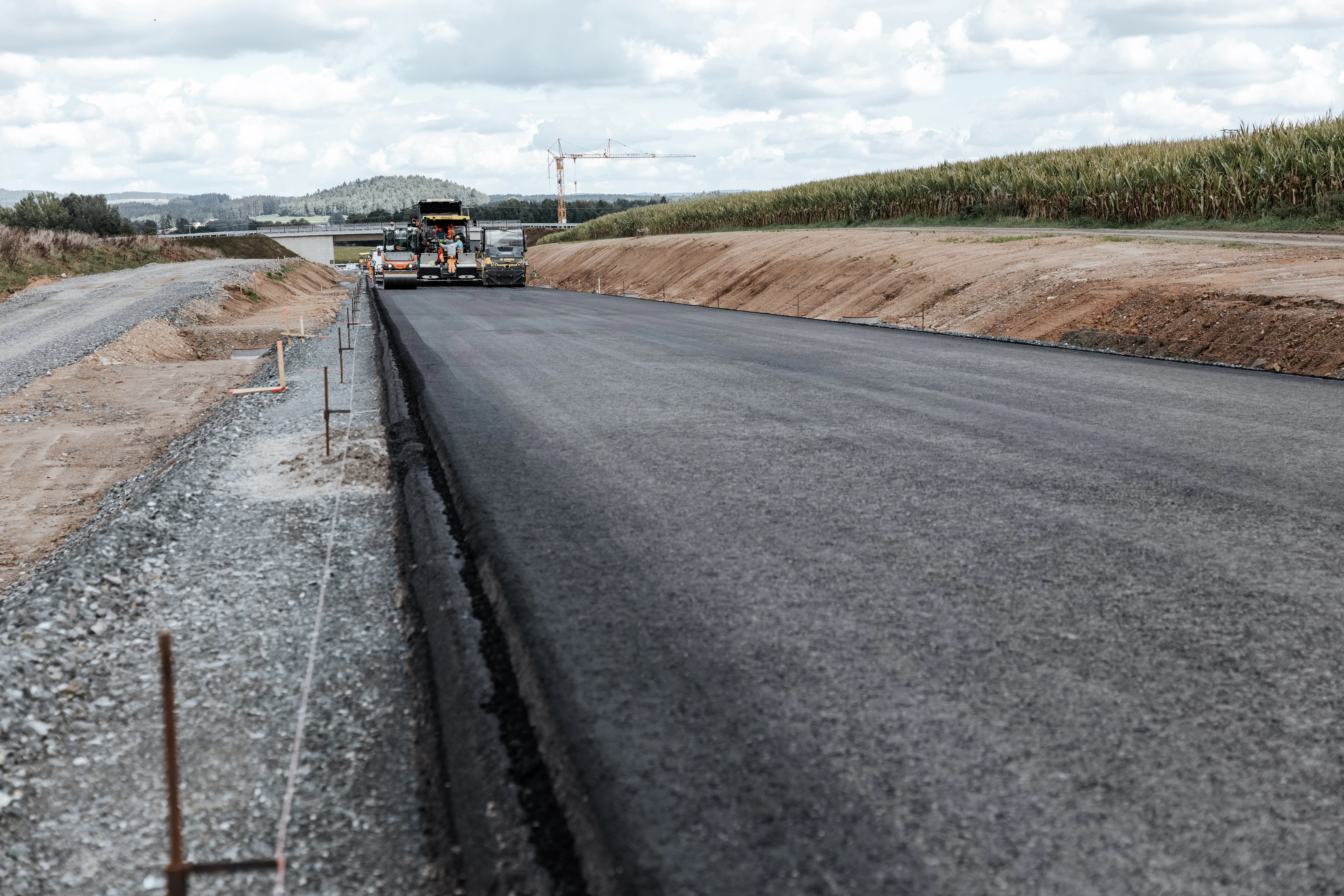 Asphaltbau-Kolonne bei der Asphaltierung der Ortsumgehung Rötz