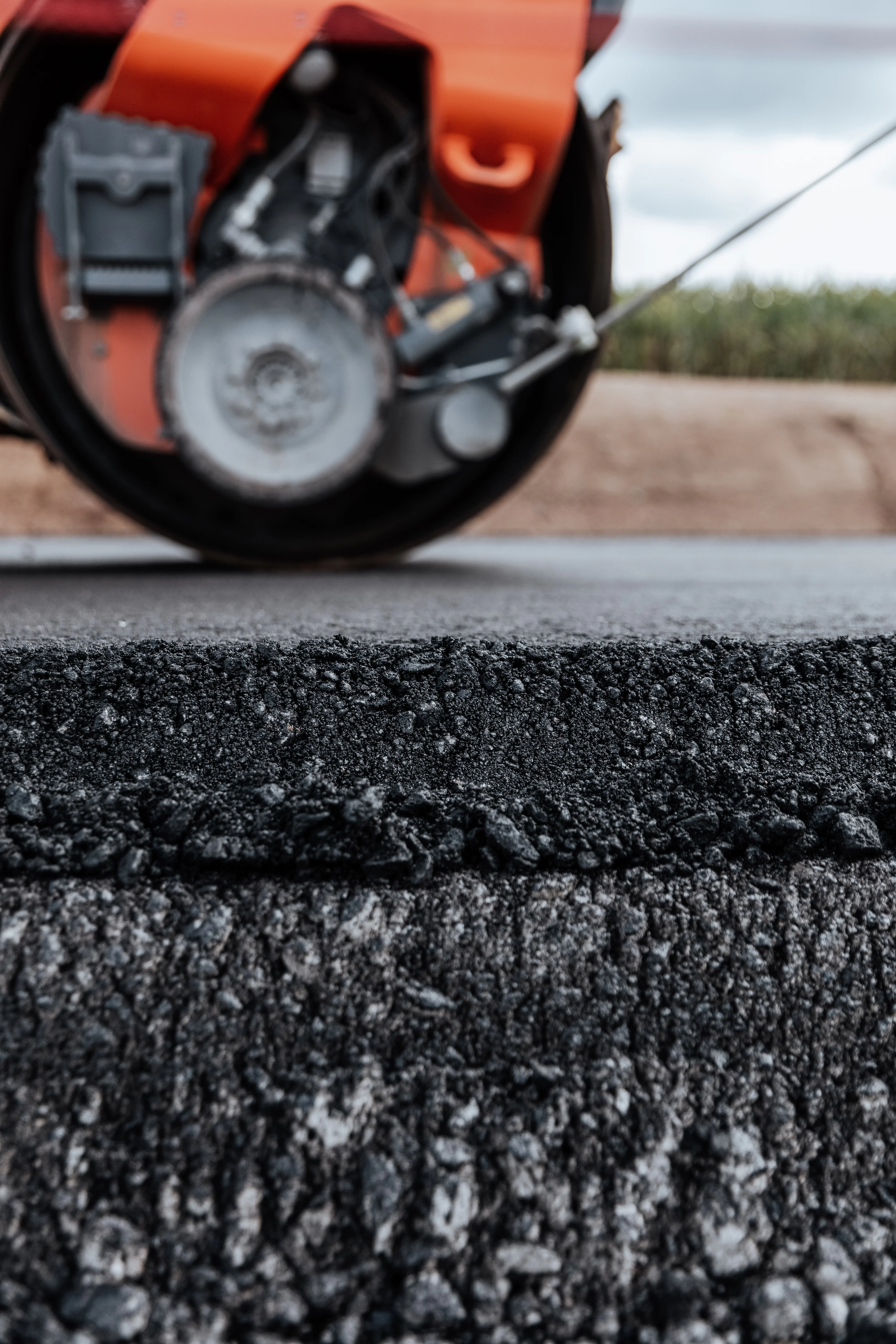 Hauseigener Asphalt bei Rädlinger: Walze rollt über asphaltierte Straße, Detailaufnahme