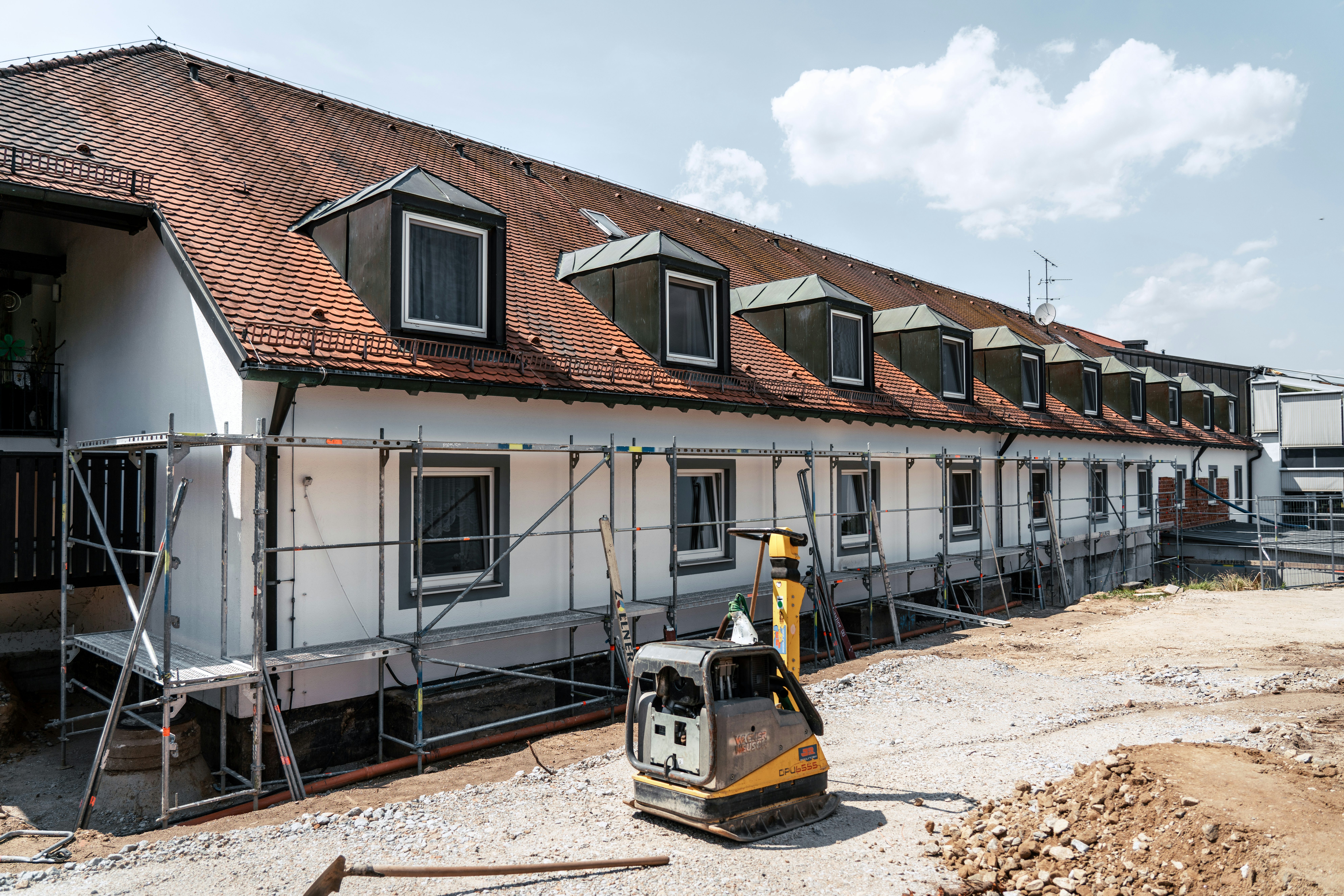Rüttelplatte vor einem Bestandsneubaugebäude