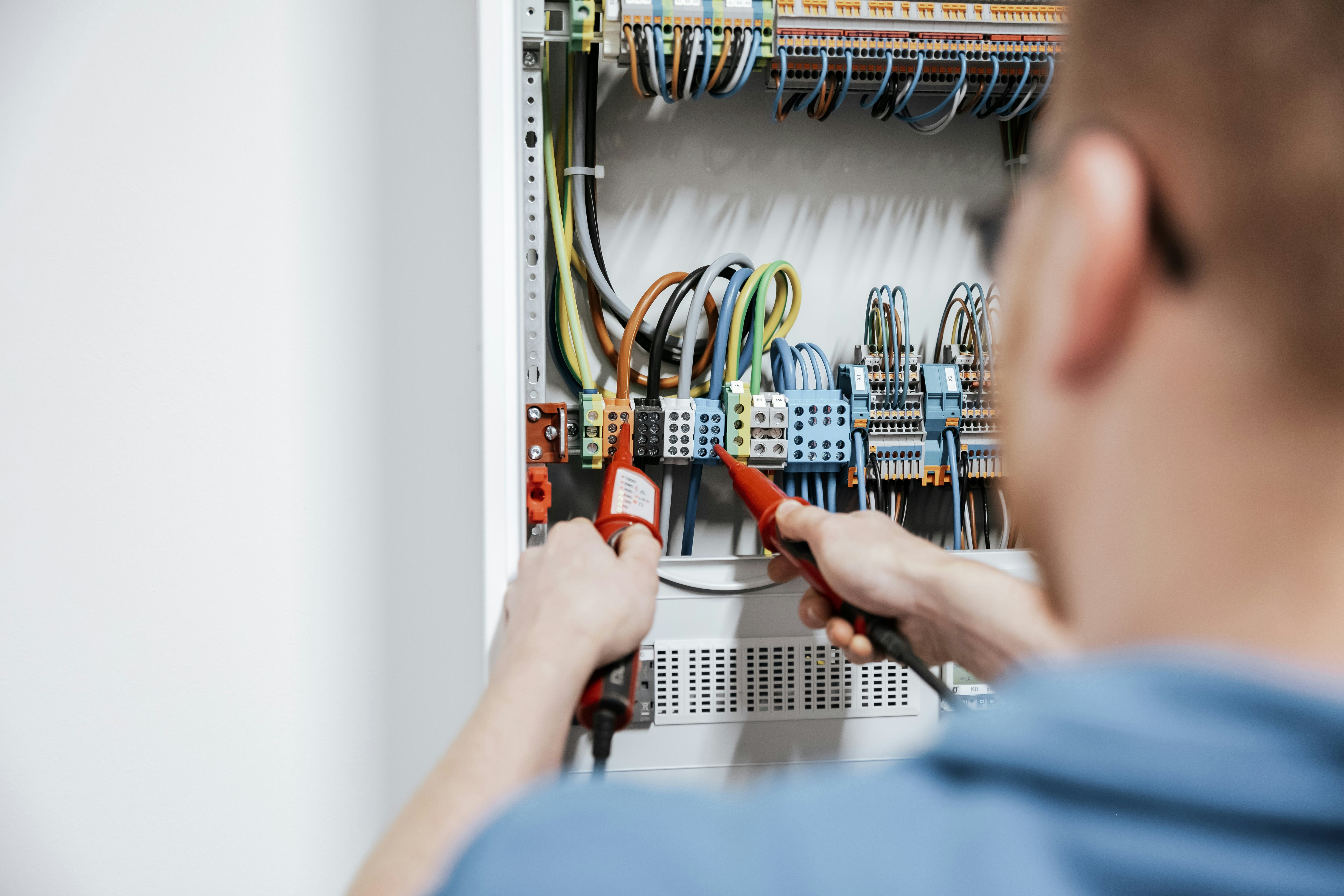 Rädlinger Elektrotechnik: Mitarbeiter misst Leitungen in Schaltkasten