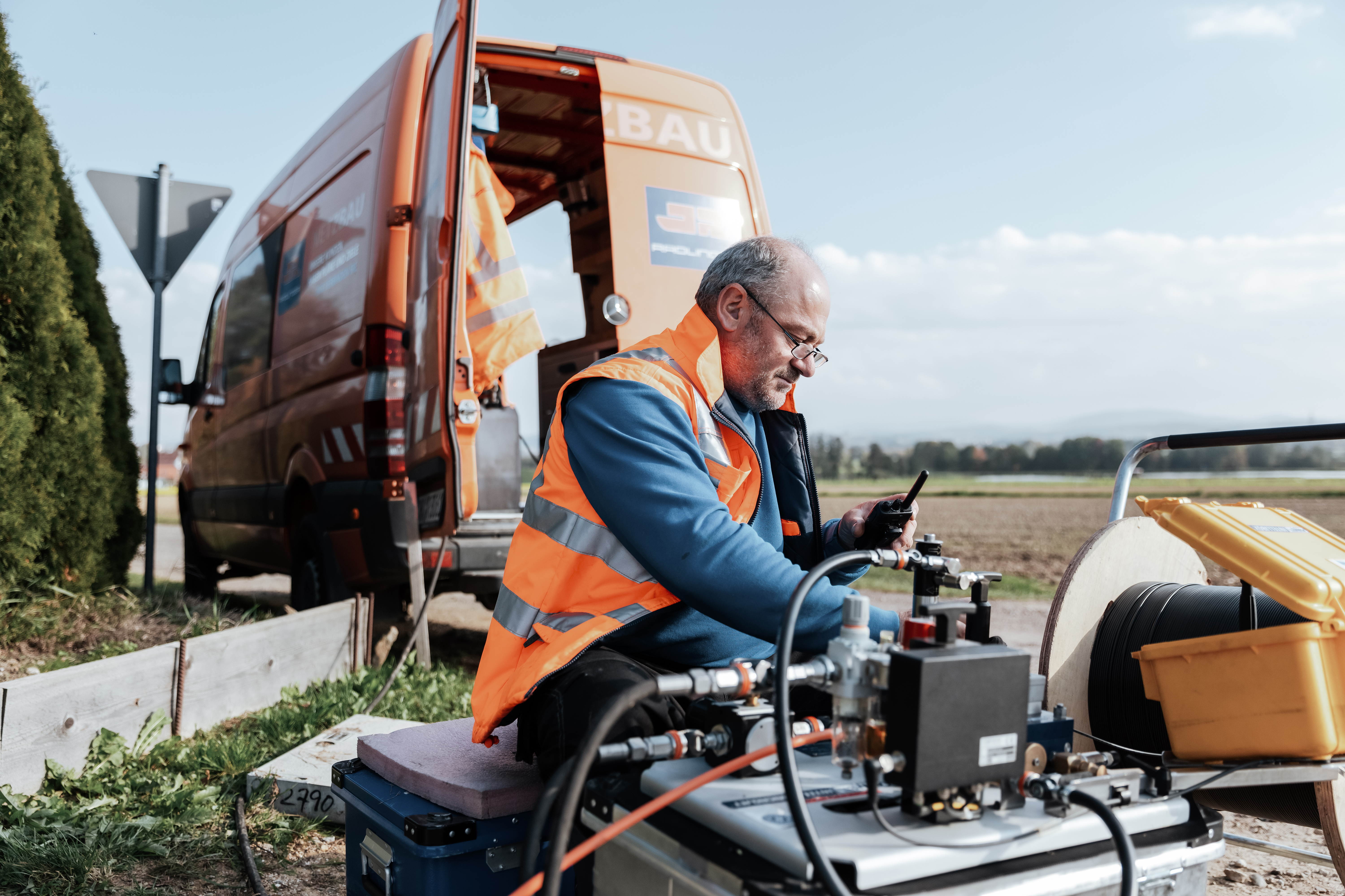 Mitarbeiter bläst Glasfaserkabel in Leerrohr ein