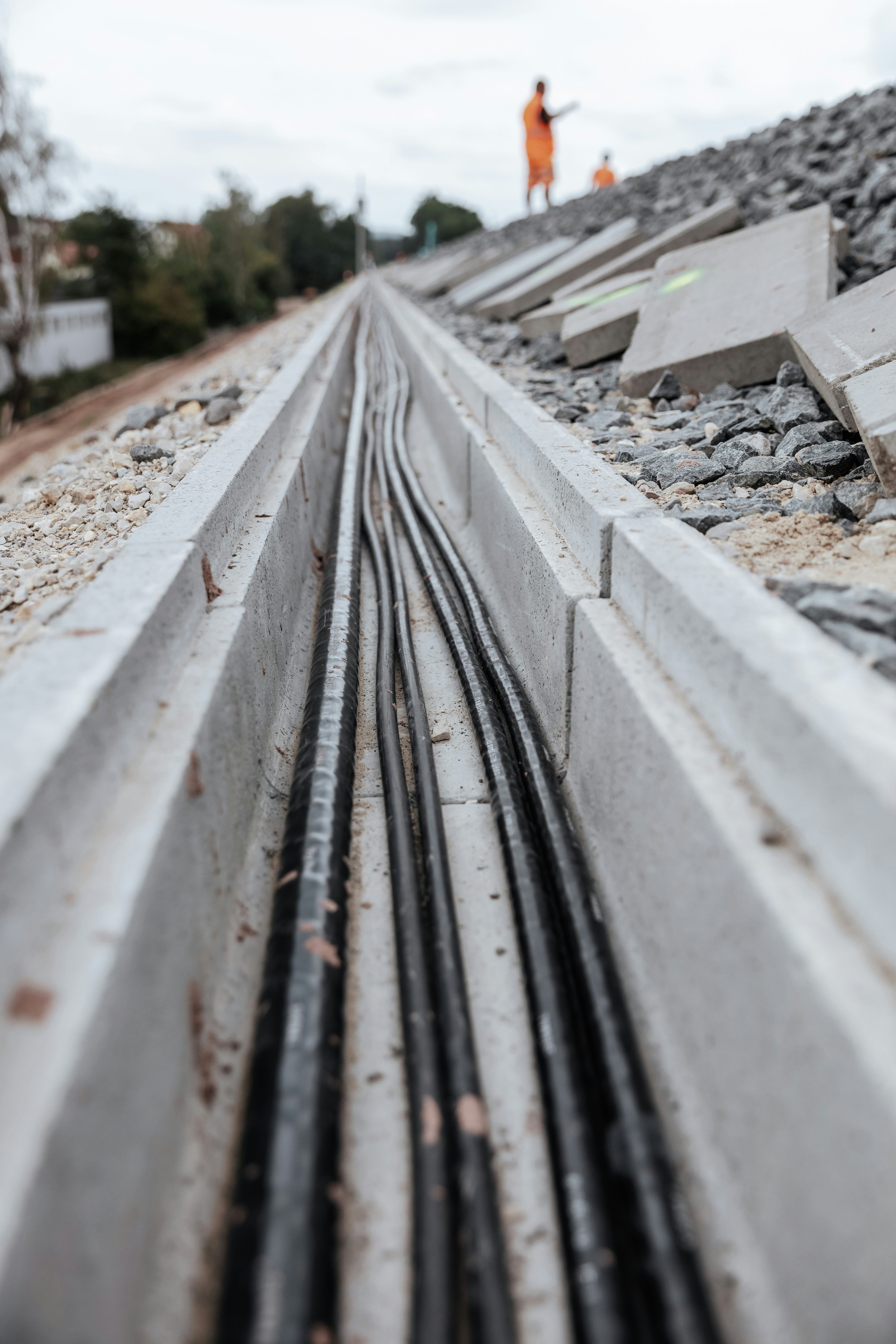 Detailaufnahme eines Kabelkanals, der neben einer Bahnstrecke verläuft