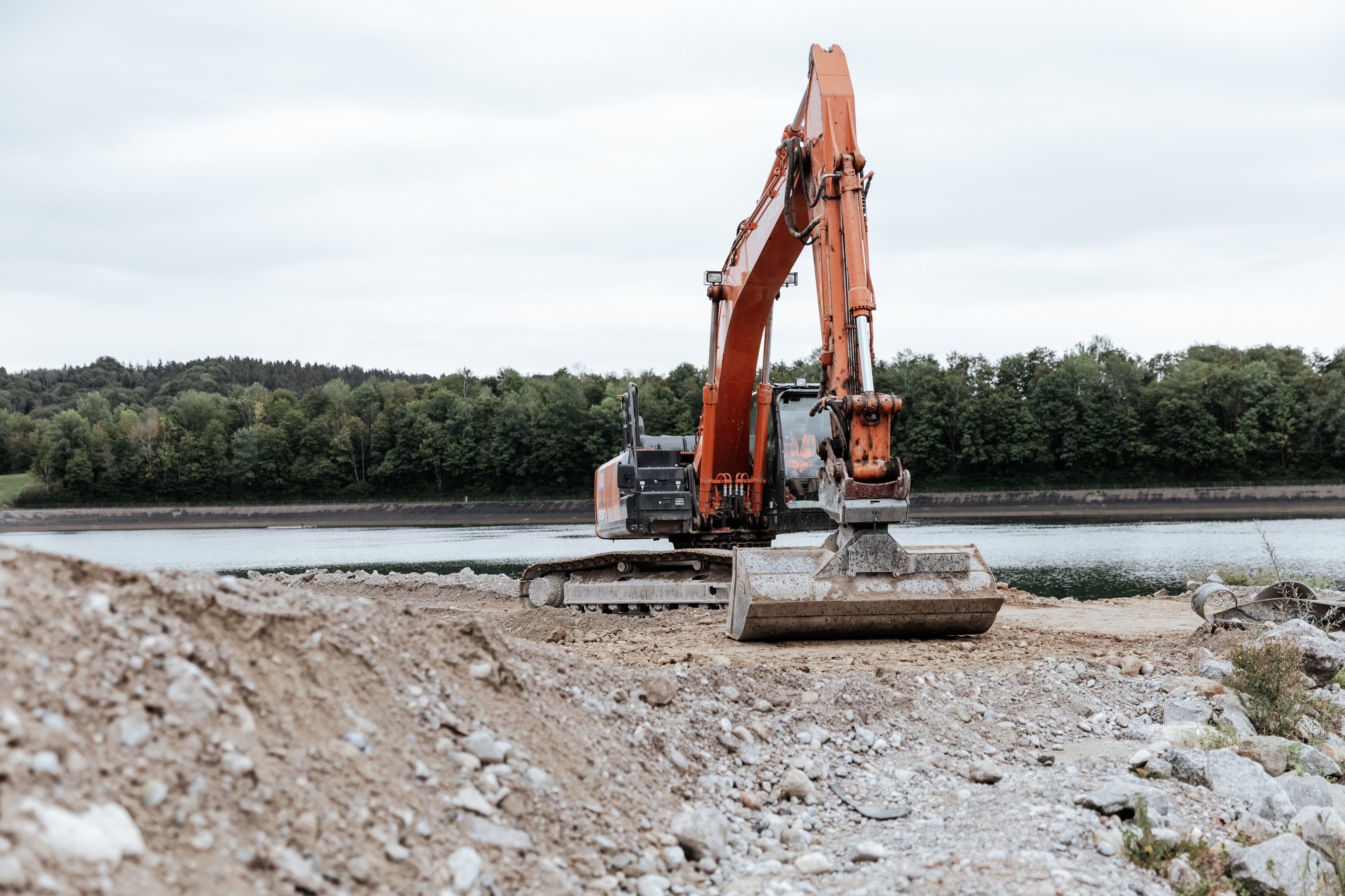 Rädlinger Wasserbau: Bagger steht am Ufer eines Regenrückhaltebeckens