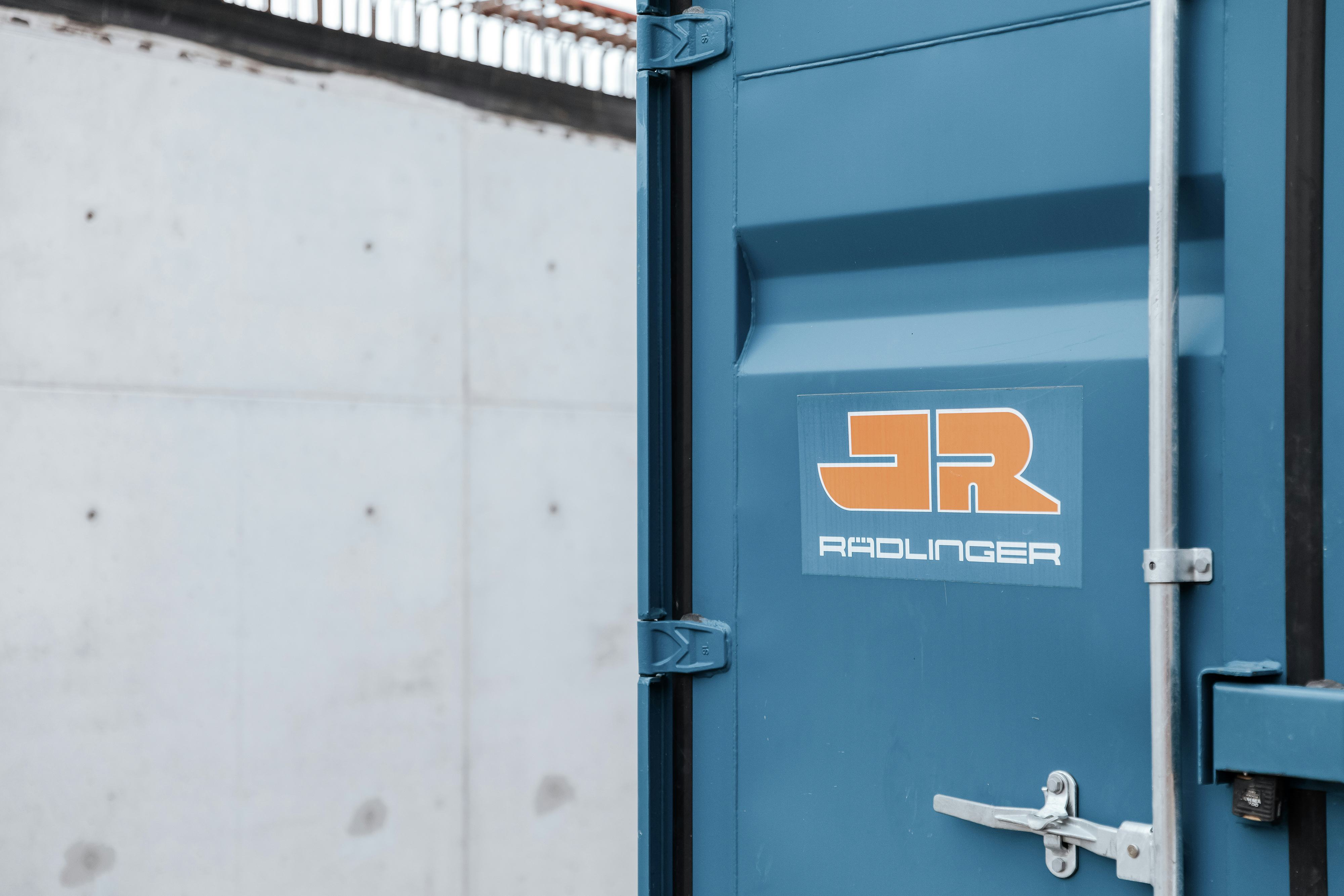 Rädlinger Standort in Hochdorf: blauer Bürocontainer mit Rädlinger Logo von außen