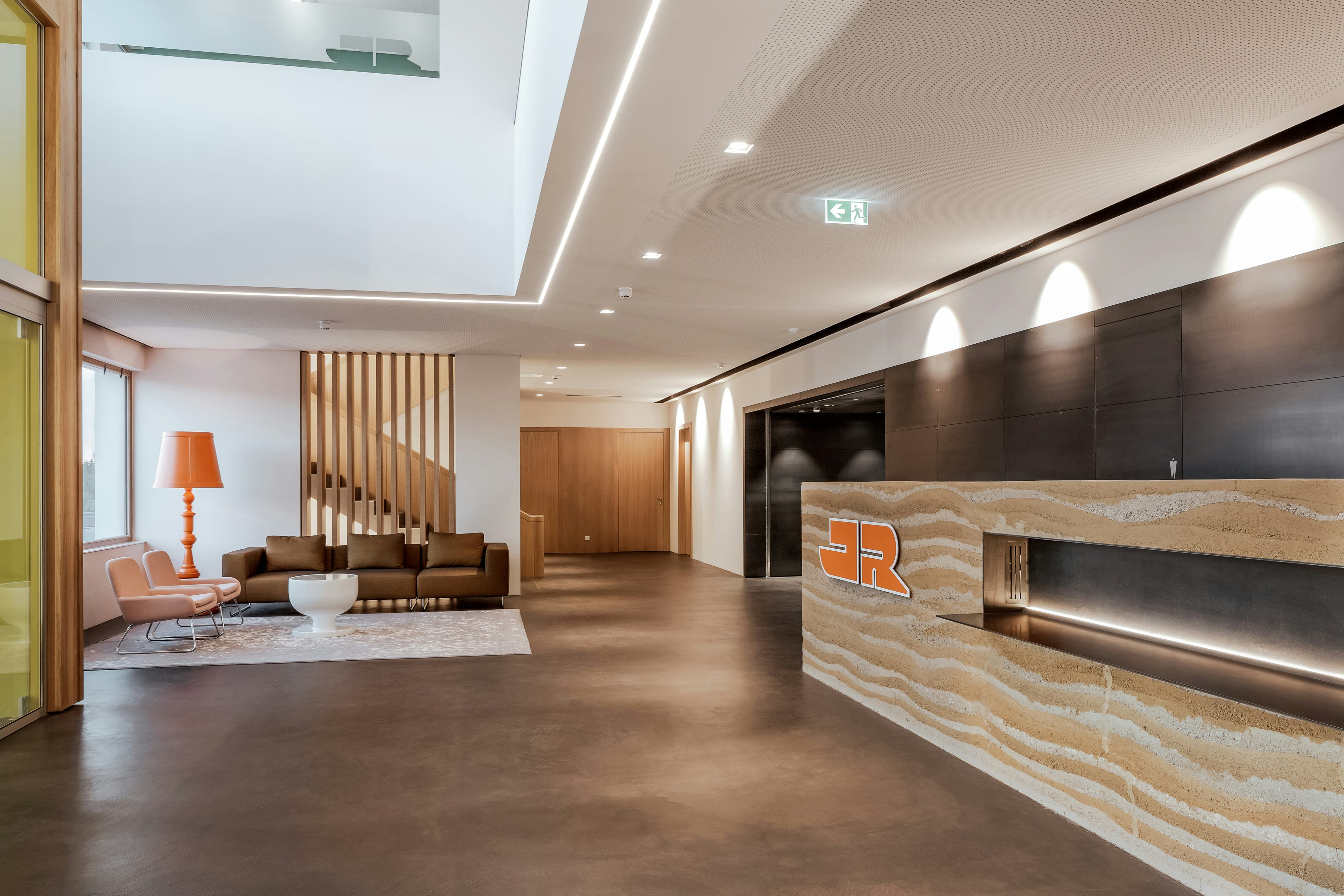 Rädlinger Standort in Windorf: moderner und lichtdurchfluteter Eingangsbereich des Bürogebäudes von innen mit Holzelementen