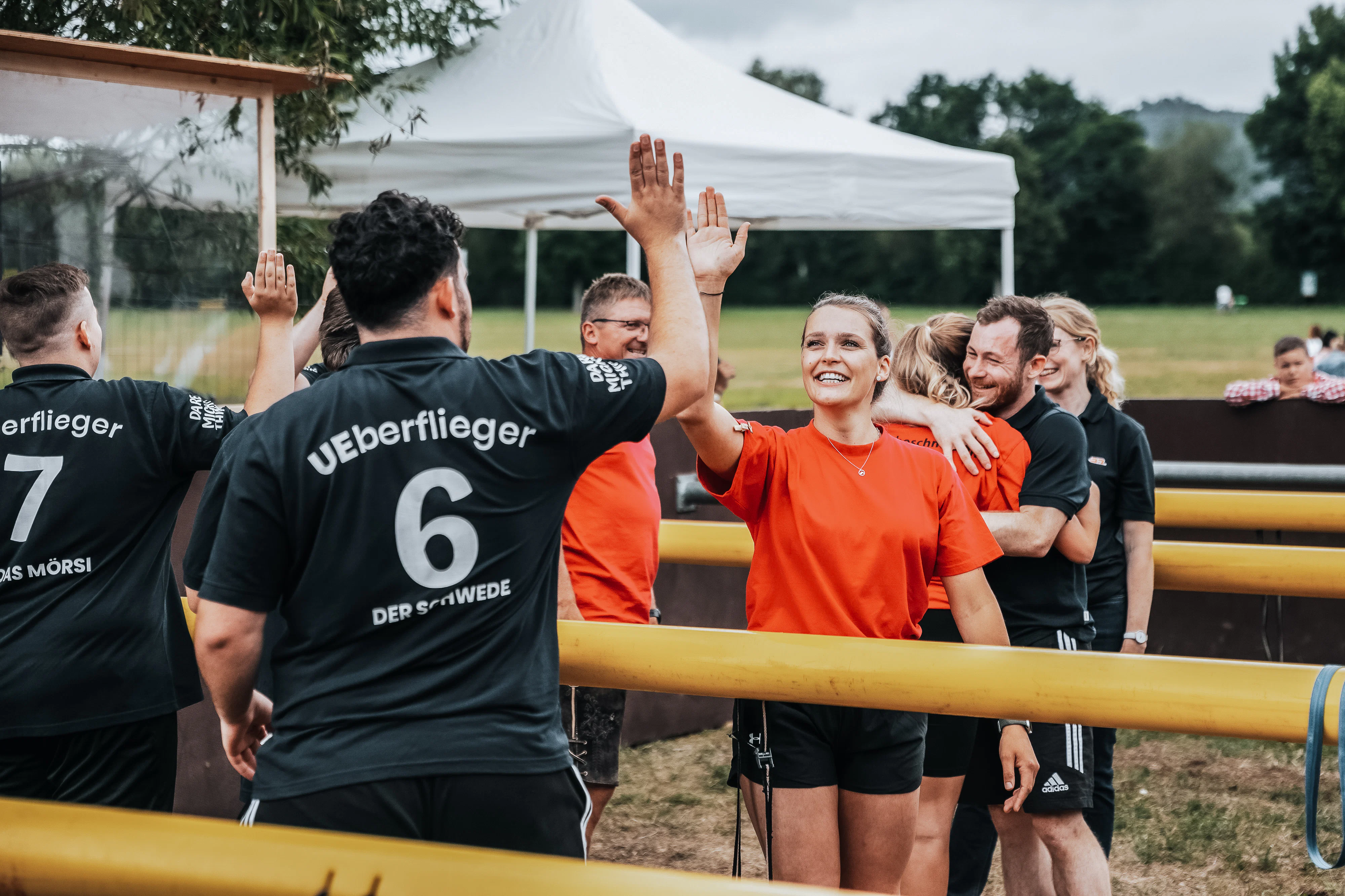 Rädlinger Sommerfest: Mitarbeitende bei Lebendkickertunier beim Hände Abklatschen und Umarmen